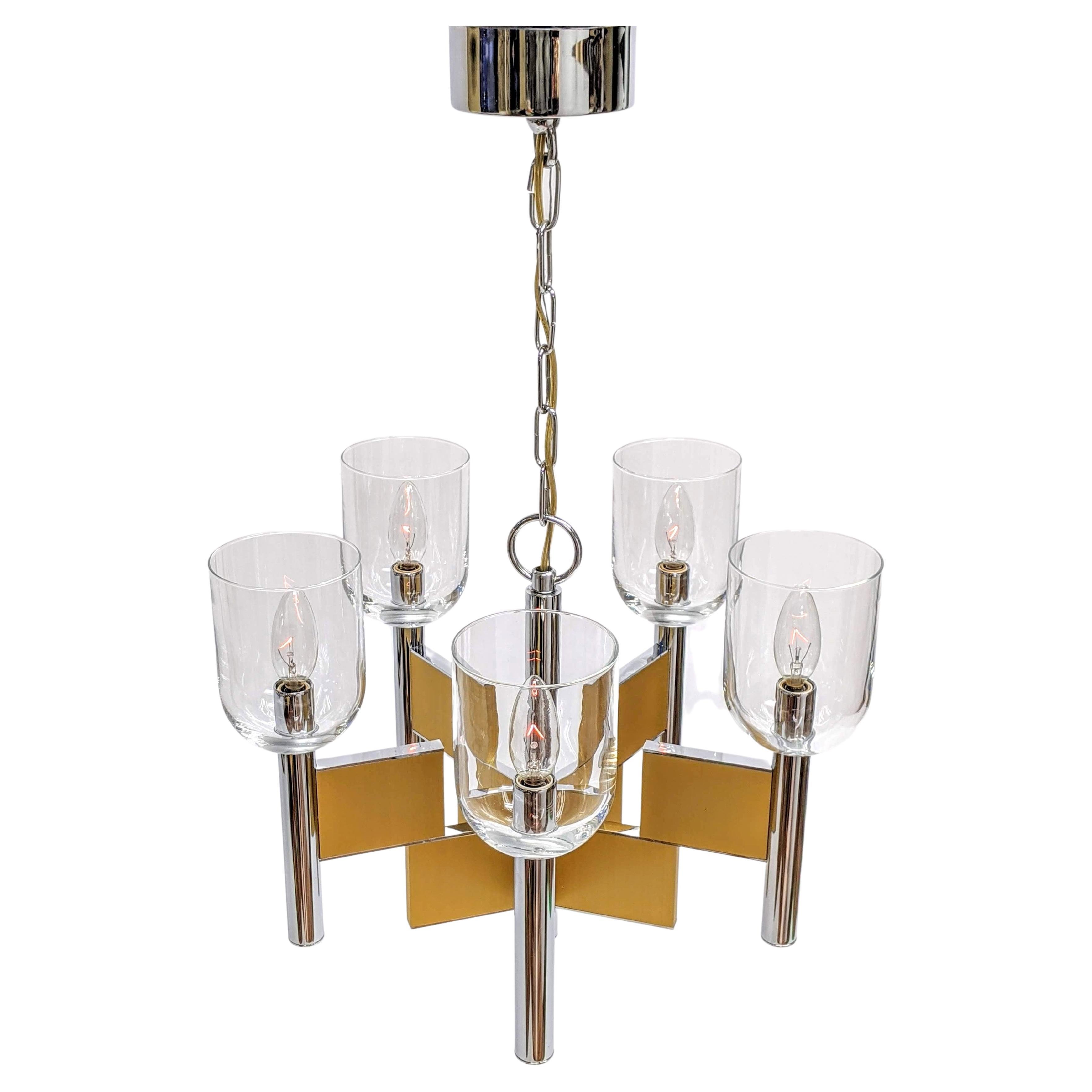 Mouth blowed glass hurricane chandelier made of thick chromed steel and brass.

Prime quality material, solid construction.

Chandelier measure 17 in. wide by 13 in. high.

Chain lenght with canopy 13 in. high. Could be ajusted. 

5 E12 candelabra