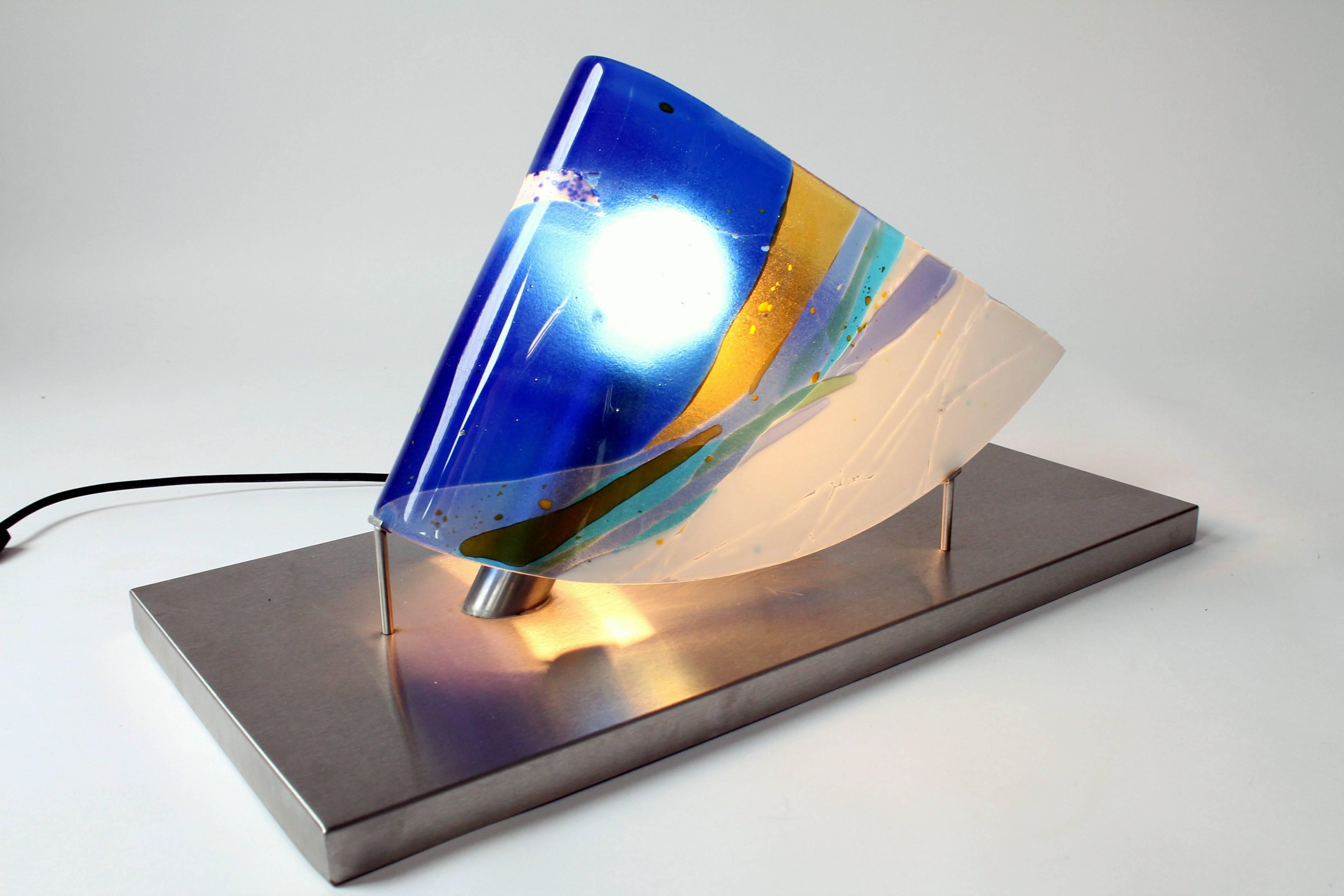 Superbe couleur frappante sur une sculpture ailée en verre fondu.

Un design et un savoir-faire de premier ordre.

Base en acier inoxydable.

Douille ordinaire E26.