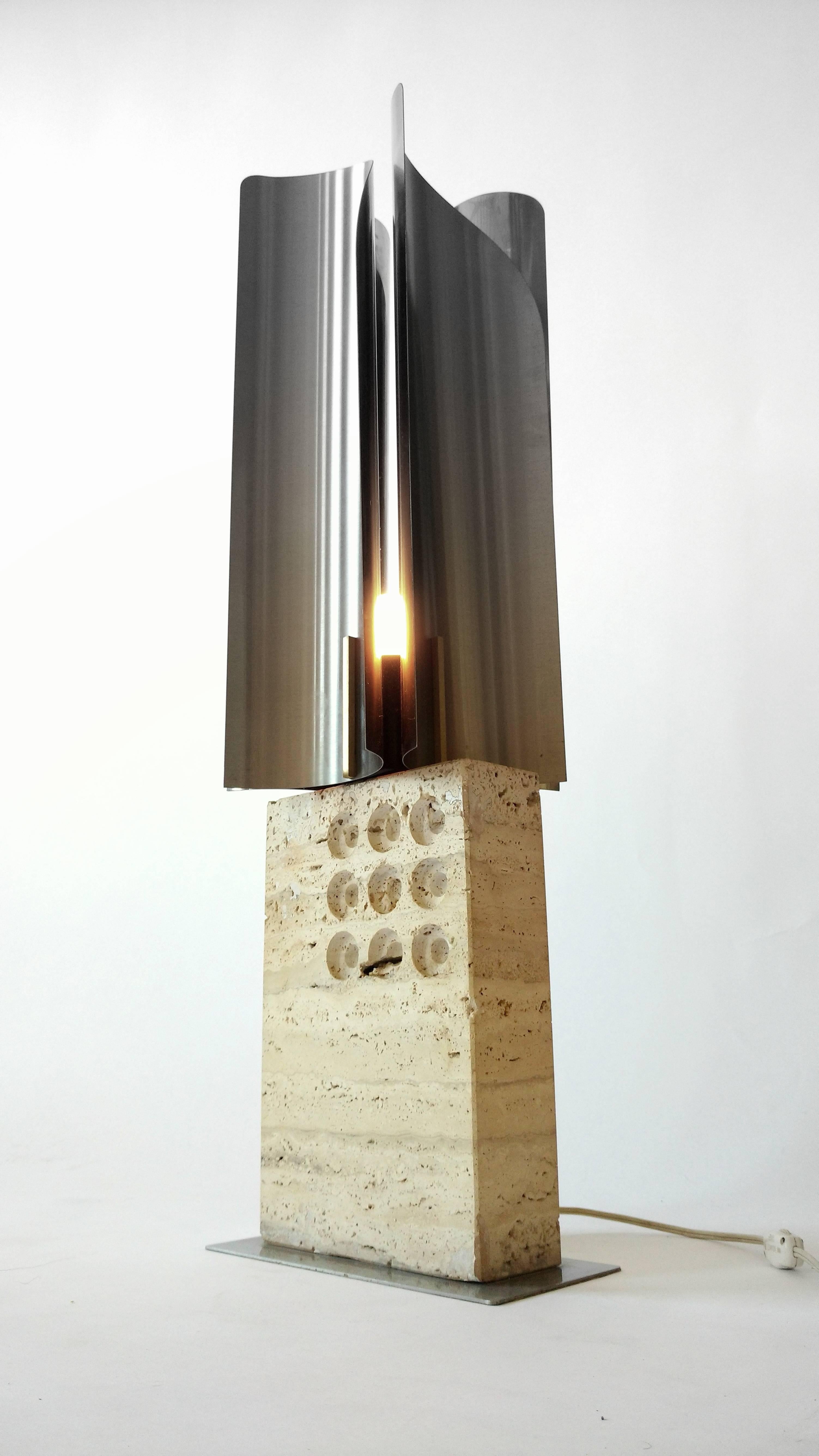 Italian lighting art piece from Reggiani
Travertine, stainless steel and brass accent

Regular E26 North American socket

Measure 31 inches high . Travertine base is  8 in. wide by 3 in. thick  

Stainless steel sculpture/shade is 8 in. wide 