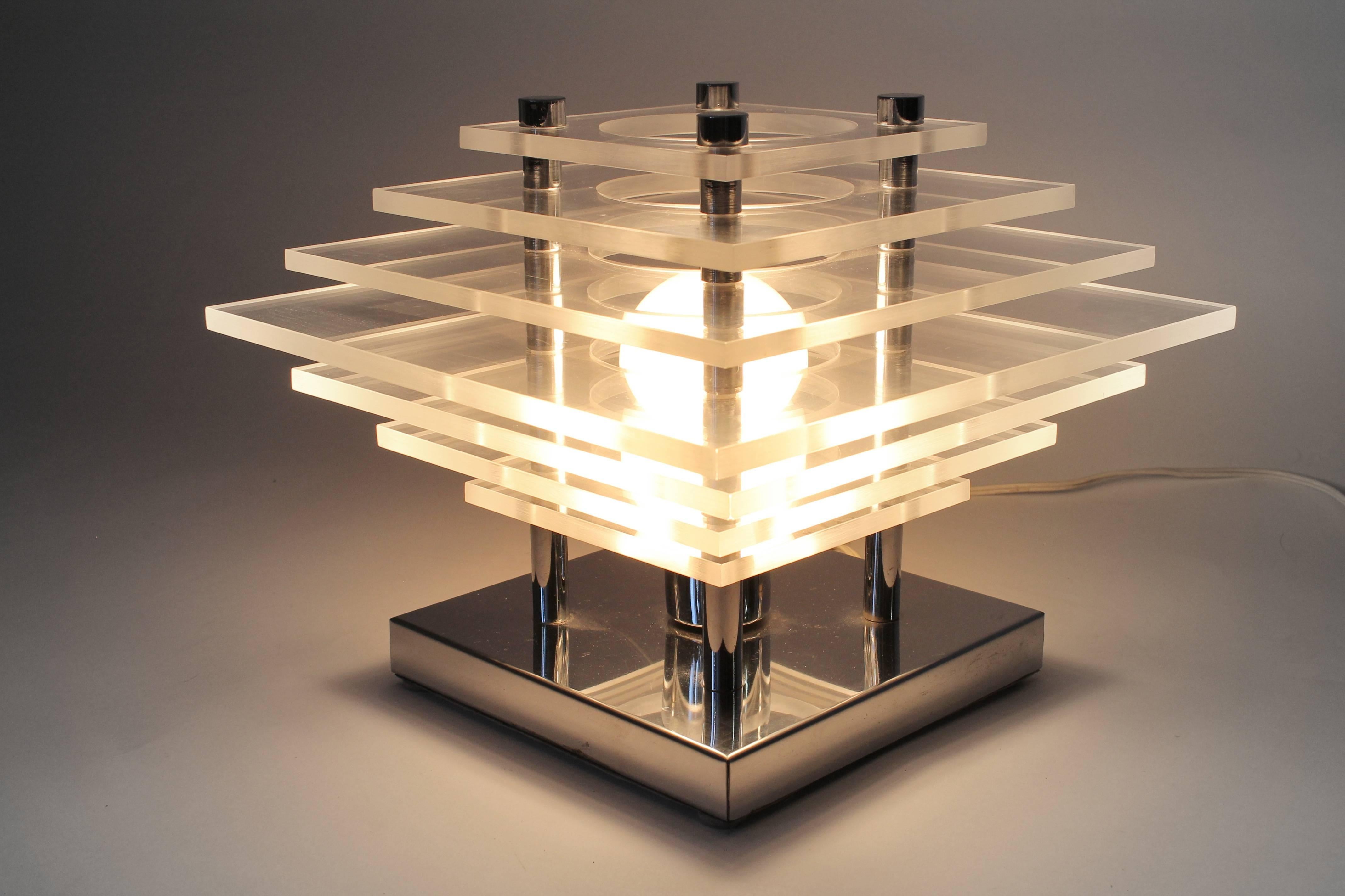 Lampe de table moderne minimaliste sculpturale en plexiglas empilé sur une base chromée. 

Le bord du plexiglas accroche les lumières de manière ludique.

Solide, bien fabriqué avec des matériaux de qualité. 

Une douille ordinaire de taille