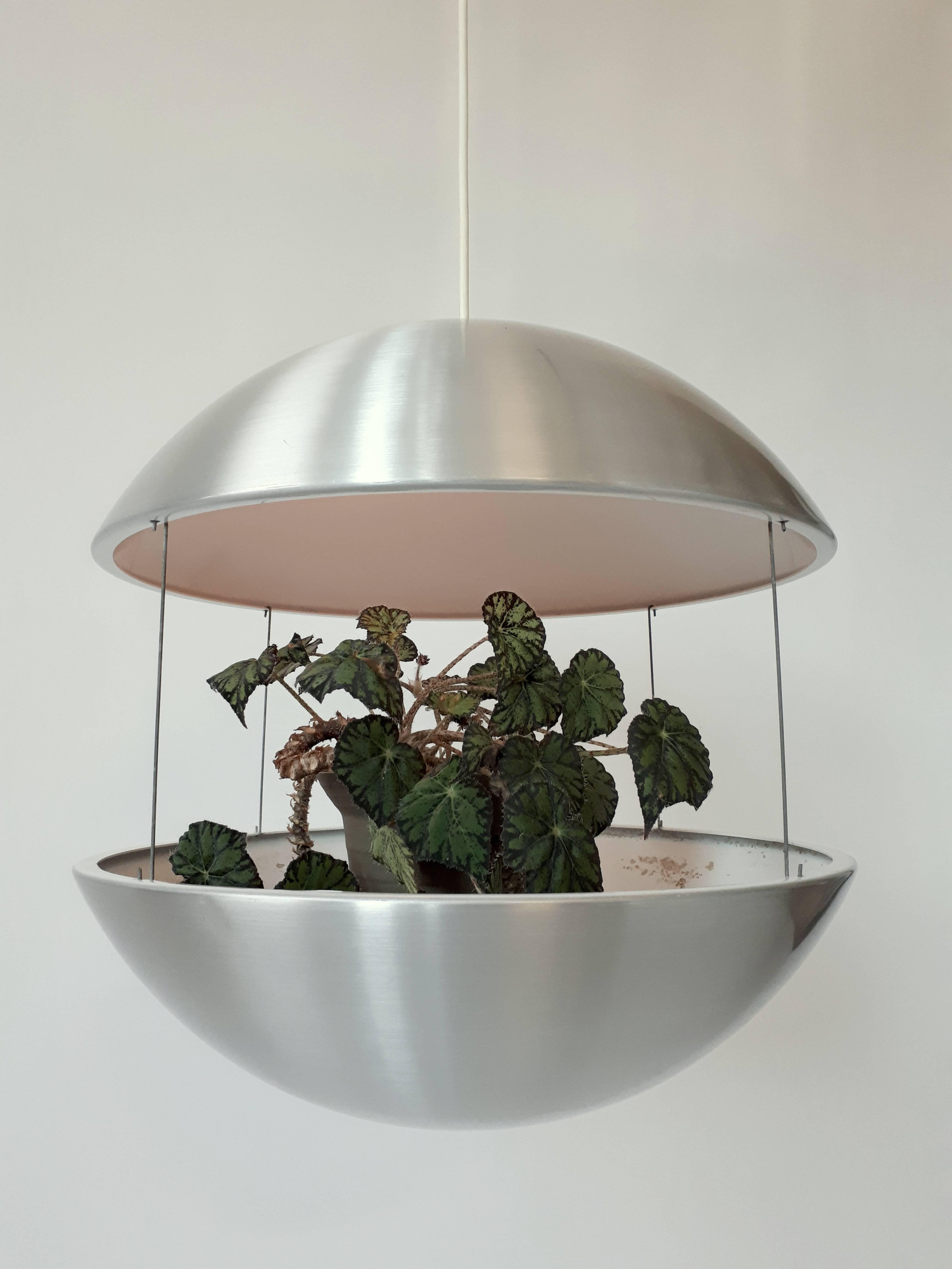 Large lighted planter pendant consisting of two brushed and lacquered aluminium halves hung together by four thin steel rods. 

The vented top part has a regular E26 size socket rated at 60 watts max. 

Measure 18 inches wide by 18 inches high.