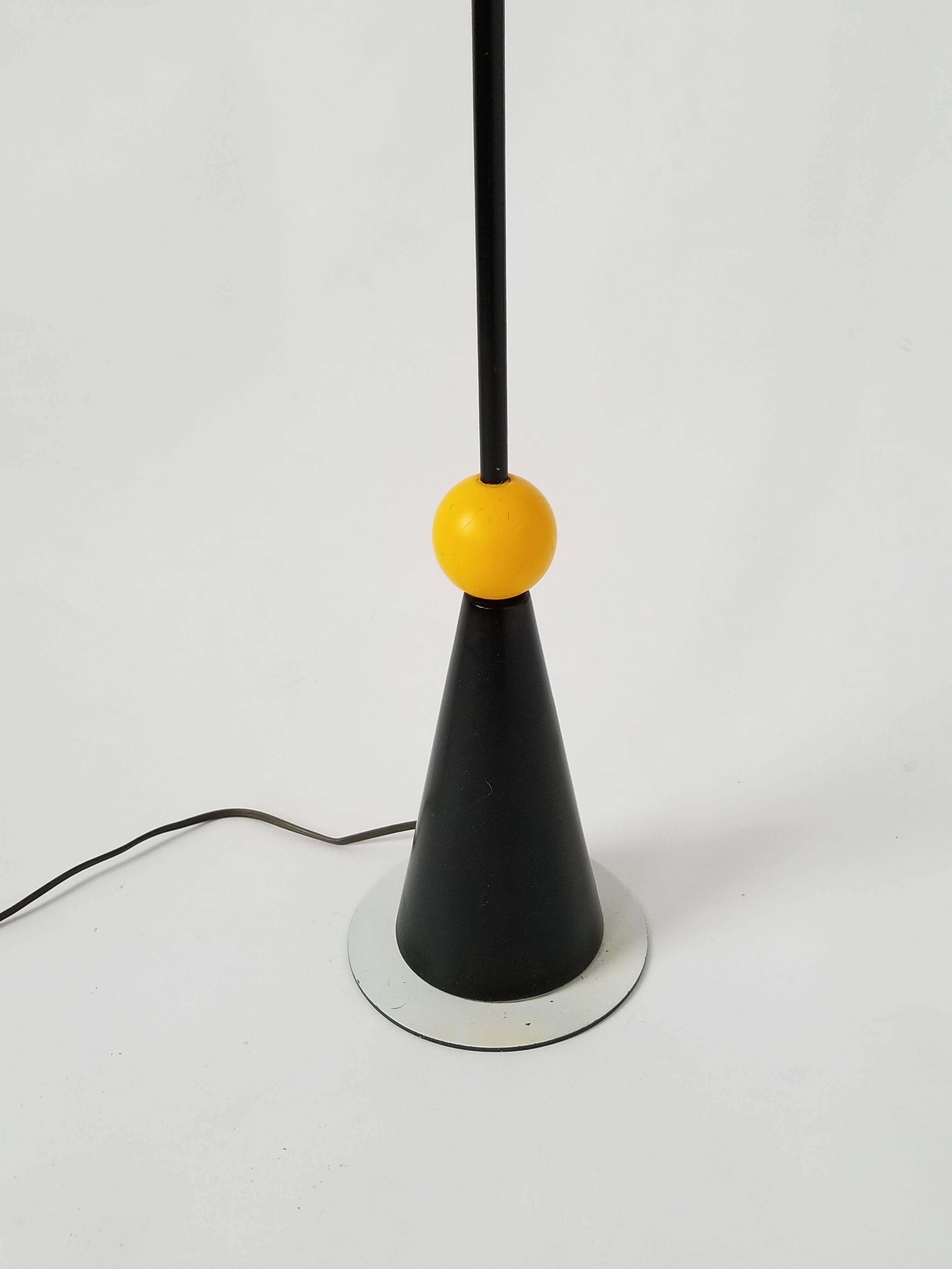 Ce lampadaire coloré et audacieux, inspiré de Memphis, a de la personnalité.

Abat-jour en verre, tige en métal noir émaillé  balle en bois laqué. 

Mesure : 48 pouces de haut. 

Contient deux douilles de type candélabre E12.