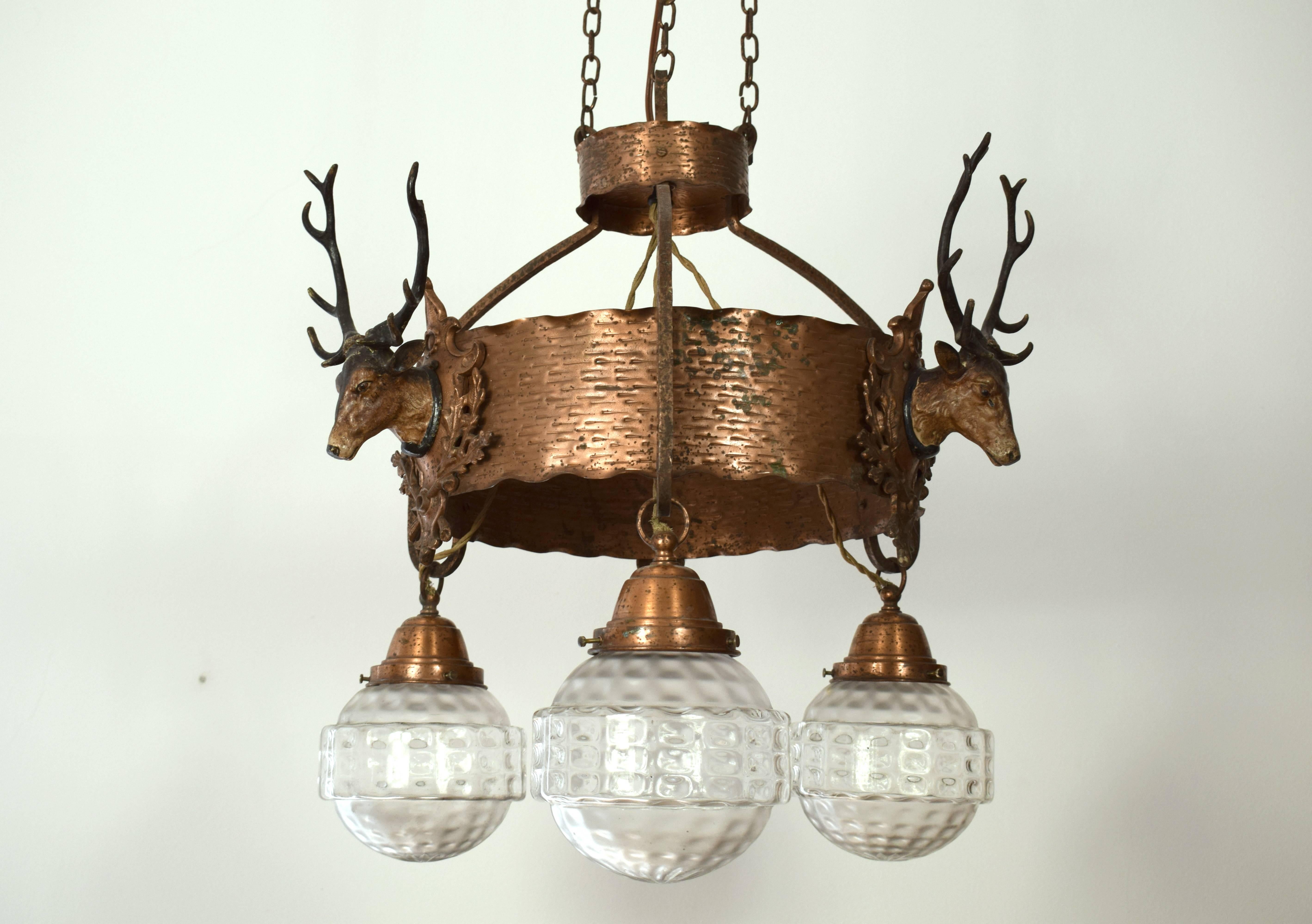Exquisite chandelier of a hunting lodge in lower Austria. Excellent ironwork. Three sockets. Three deer from metal and cold painted. Material: Copper (or wrought iron copper plated). Very good original condition!
The glass shades were obtained and