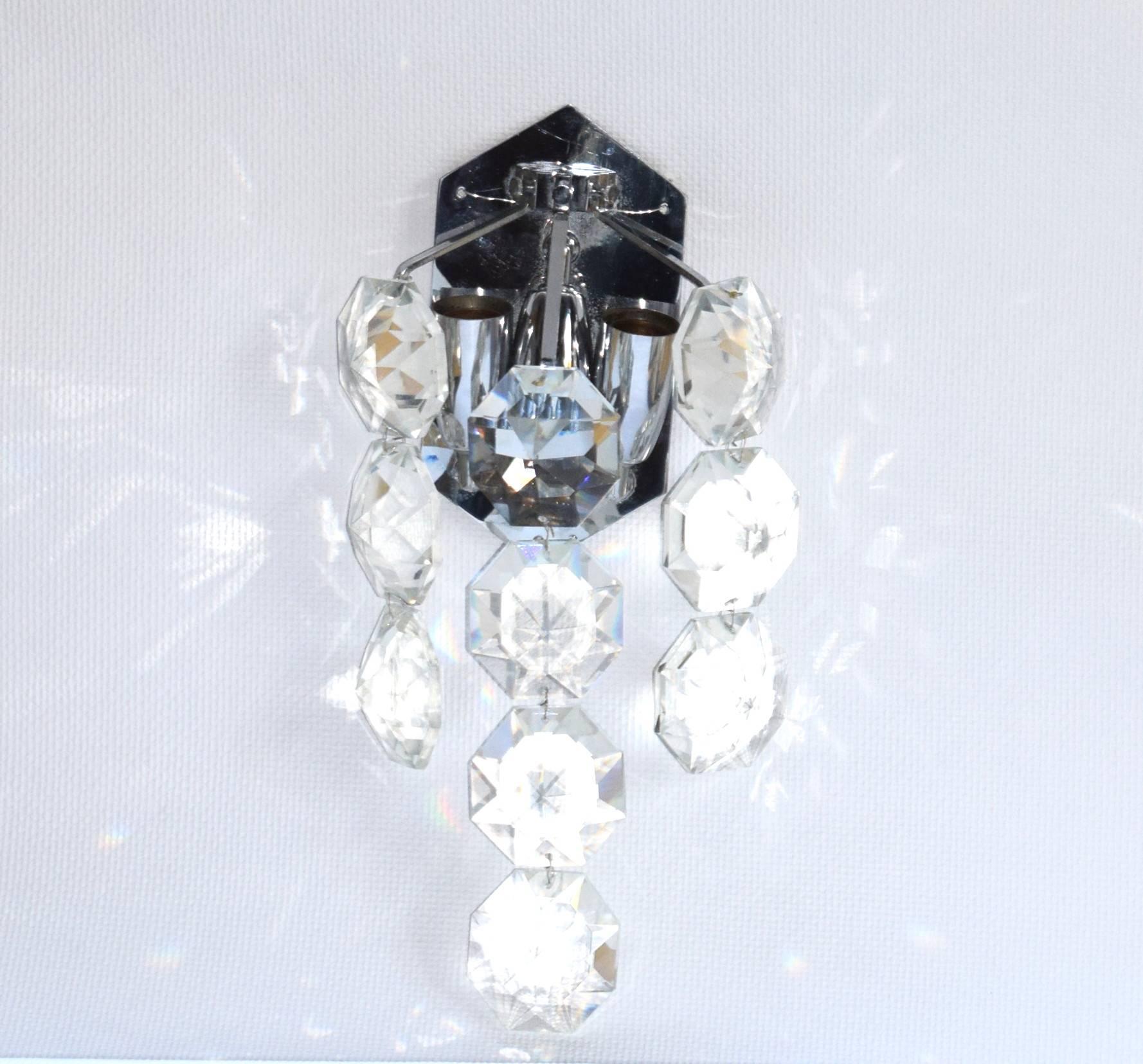 Gorgeous wall sconce by Bakalowits & Sohne featuring a multitude of very uniquely sized large (each 6.5 x 6.5 cm) and exquisite with big sparkling octagon gem-like crystals hanging from a nickeled brass frame. Three bulbs are illuminating this
