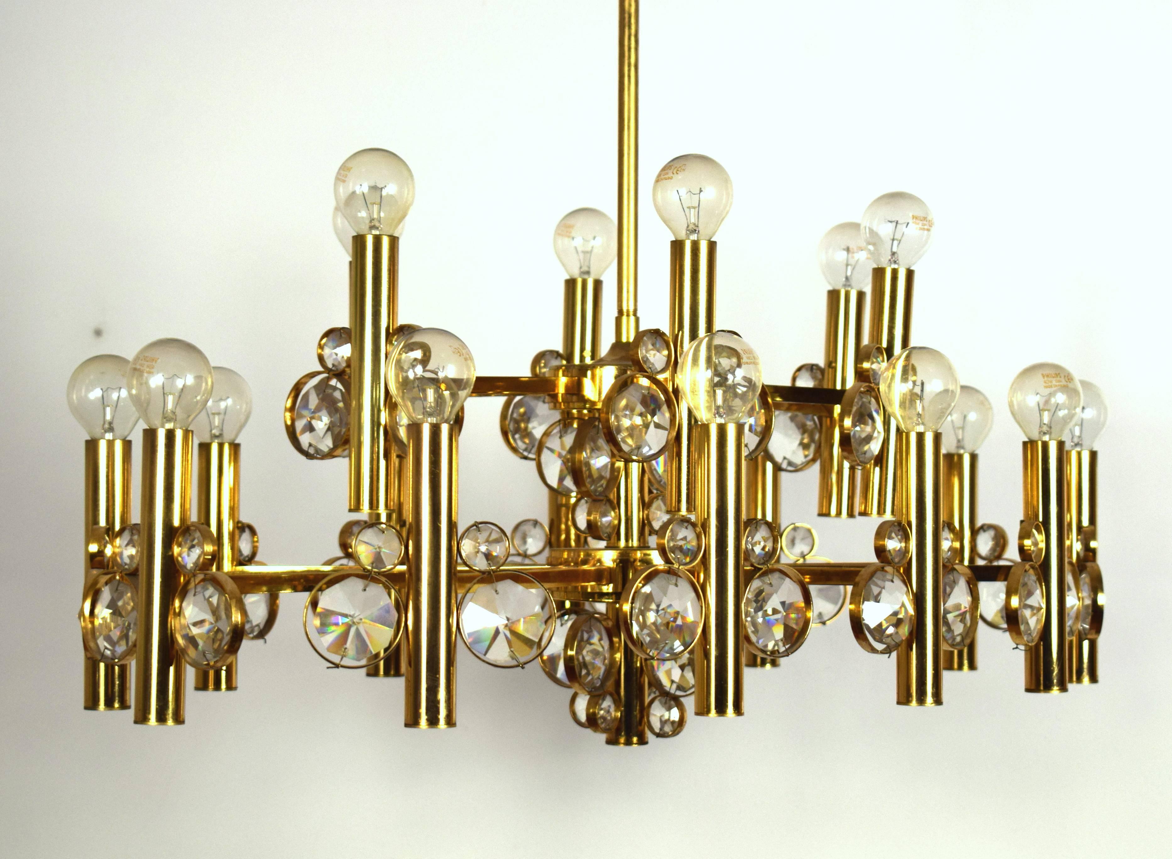 Very impressive eighteen-arm chandelier in the style of Bakalowits, Palwa or Sciolari, manufactured in 1970s. 
It is made of a gilded frame (oval shape) and diamond shaped crystals. 
The chandelier has 18 sockets for small base screw bulbs up to