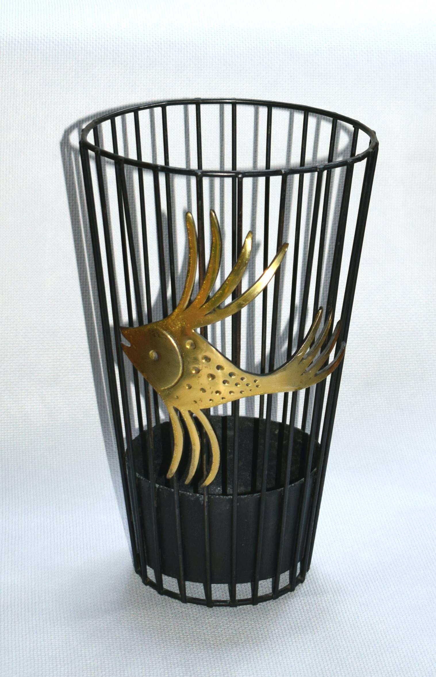 This umbrella stand was designed by Walter Bosse in Vienna. It is made from black wire steel with a bowl inside and a large and decorative brass fish on the outside.

