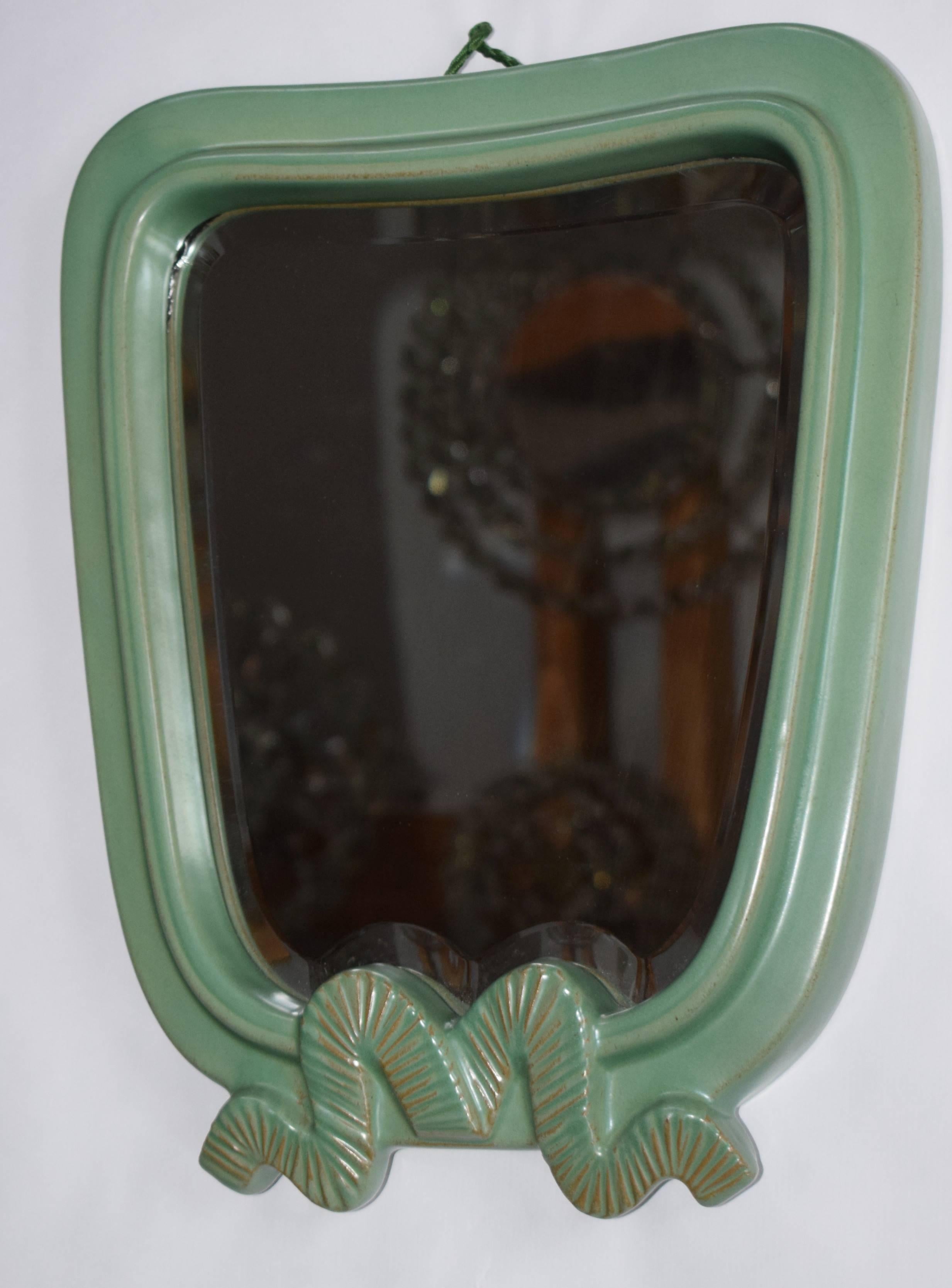 This large handmade wall mirror was manufactured by Gmundner Keramik c. in the 1930s.
Light green glaze.
The edges of the mirror are hand-cut.
Excellent design in best condition!

Measures: 40 x 32 x 5 cm.

 