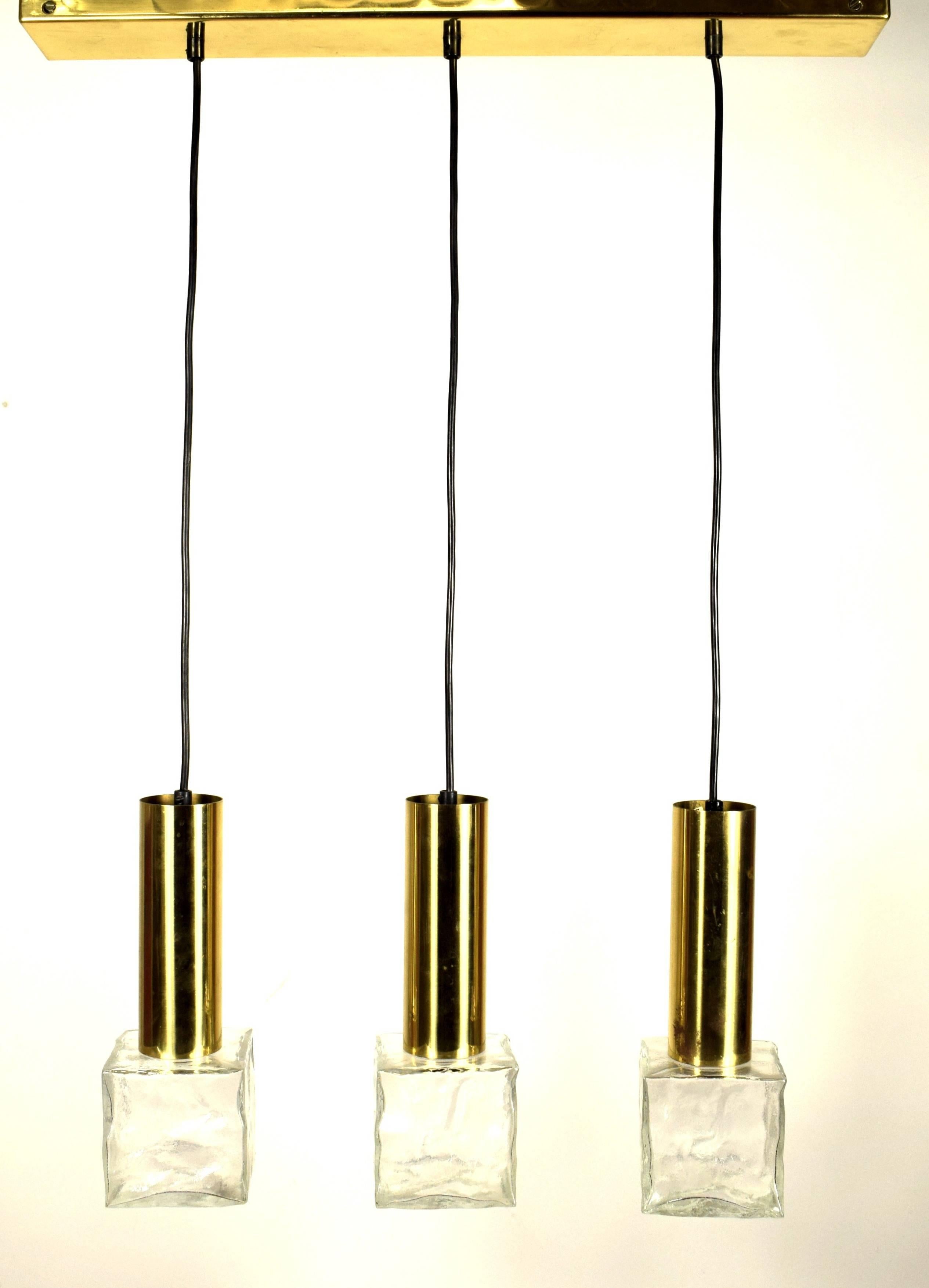 A vintage pendant lamp with three heavily textured clear cast glass cubes in its original brass finish. Signed by the Austrian maker Kalmar. 
Massive and high-quality execution. 
Variable height max. 100 cm.
Width: 62 cm. 
Excellent condition!