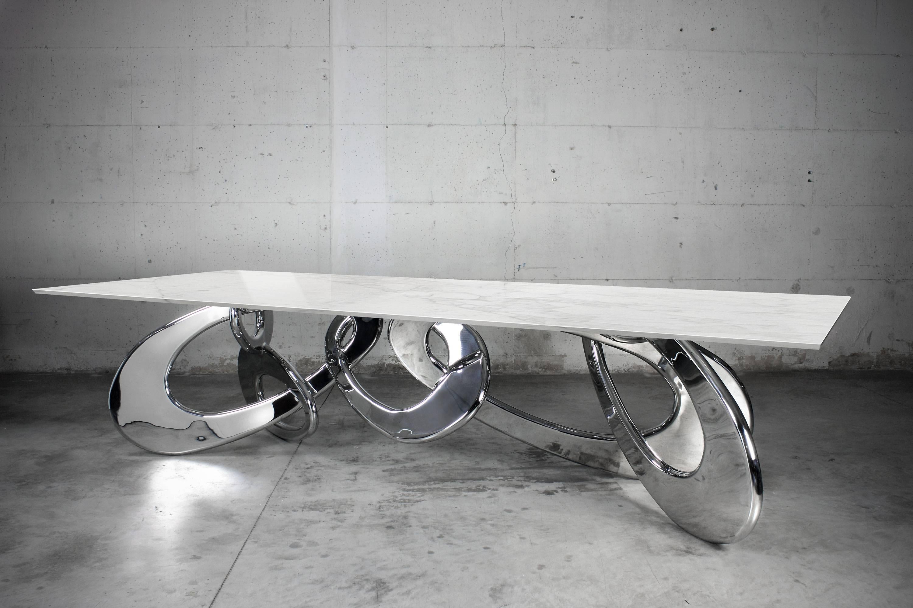 Der Tisch 'Chained up Miami' ist ein wichtiger Esstisch mit Struktur aus hochglanzpoliertem Edelstahl und Platte aus Calacatta-Marmor, Herkunft: Toskana. Jeder einzelne Armreif wird von Hand geschweißt und hochglanzpoliert. Die spiegelnde Oberfläche