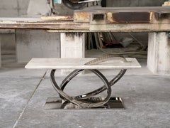 Tavolino scultoreo italiano con piano in quarzite Taj Mahal e base ad anelli in acciaio lucido