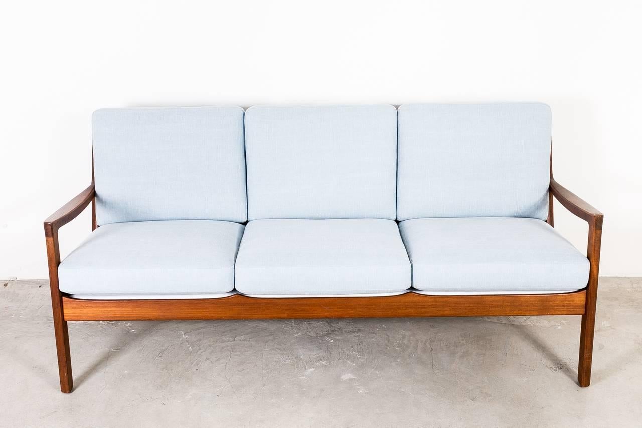 The Senator sofa was designed by Ole Wanscher for France & Son, Denmark. The sofa features a solid teak wood sofa with new upholstery and two matching armchairs.
 
