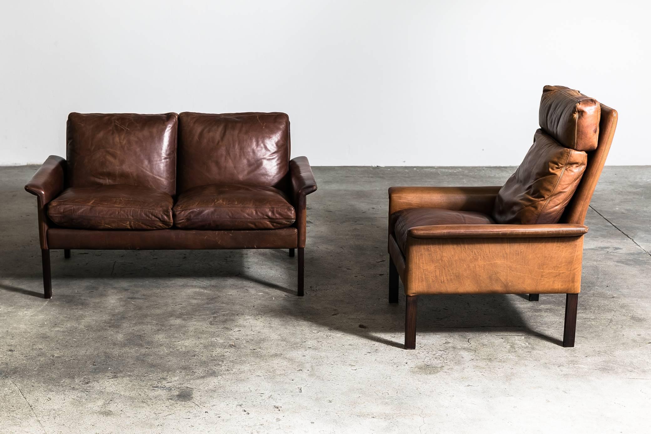 Danish sofa set of two-seat and armchair designed by Hans Olsen for C/S Mobler in 1969. Very good condition and original leather upholstery with beautiful patina. Rosewood leg and feather cushion. Dimensions: Sofa H 73cm x 130W x 80D. Chair: H 97cm