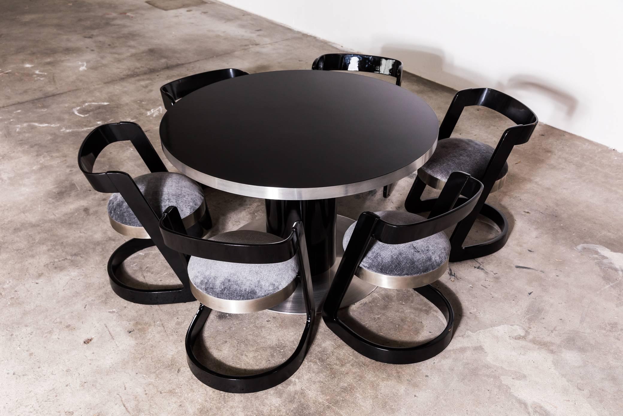 Set of dining table and six chairs by Willy Rizzo, circa 1970.
Table made of wood and steel: the surface has an elegant black gloss laminate surface framed by a steel band 5cm thick. The pedestal is laminated as the top and stands on a thick round