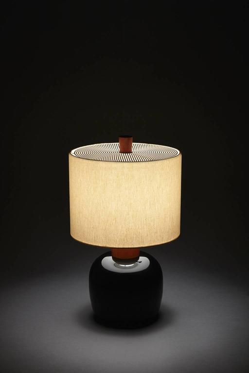 Small with a big presence, the Marty inhabits intimate spaces, scaled for the bedside or tabletop. Turned, ebonized maple base with a cherry neck and finial. This lamp is 14” tall with an 8” diameter trimless, natural linen shade. Equipped with bass