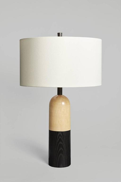 A large table lamp for an open space, the Tusten balances its substantial, geometric form with an expansive shade. The Tusten II has a base of dyed ash and honey-blonde maple, with dyed ash neck and finial. Sitting at 33” tall with 20” diameter