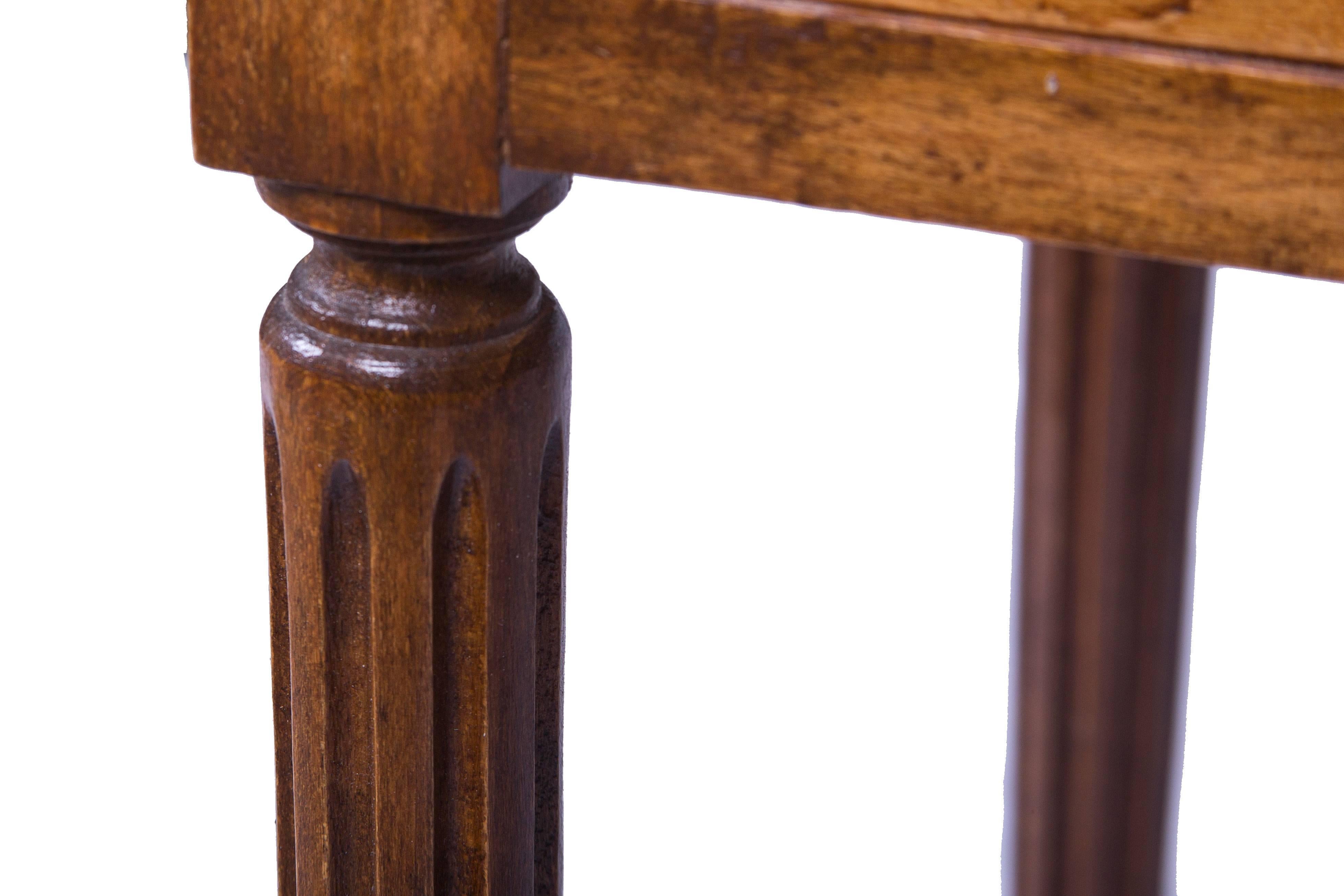 A pair of Mid-Century burled elm side tables. The gallery top over three drawers flanked by fluted styles. Raised on turned and fluted tapering legs ending in a brass CAP.