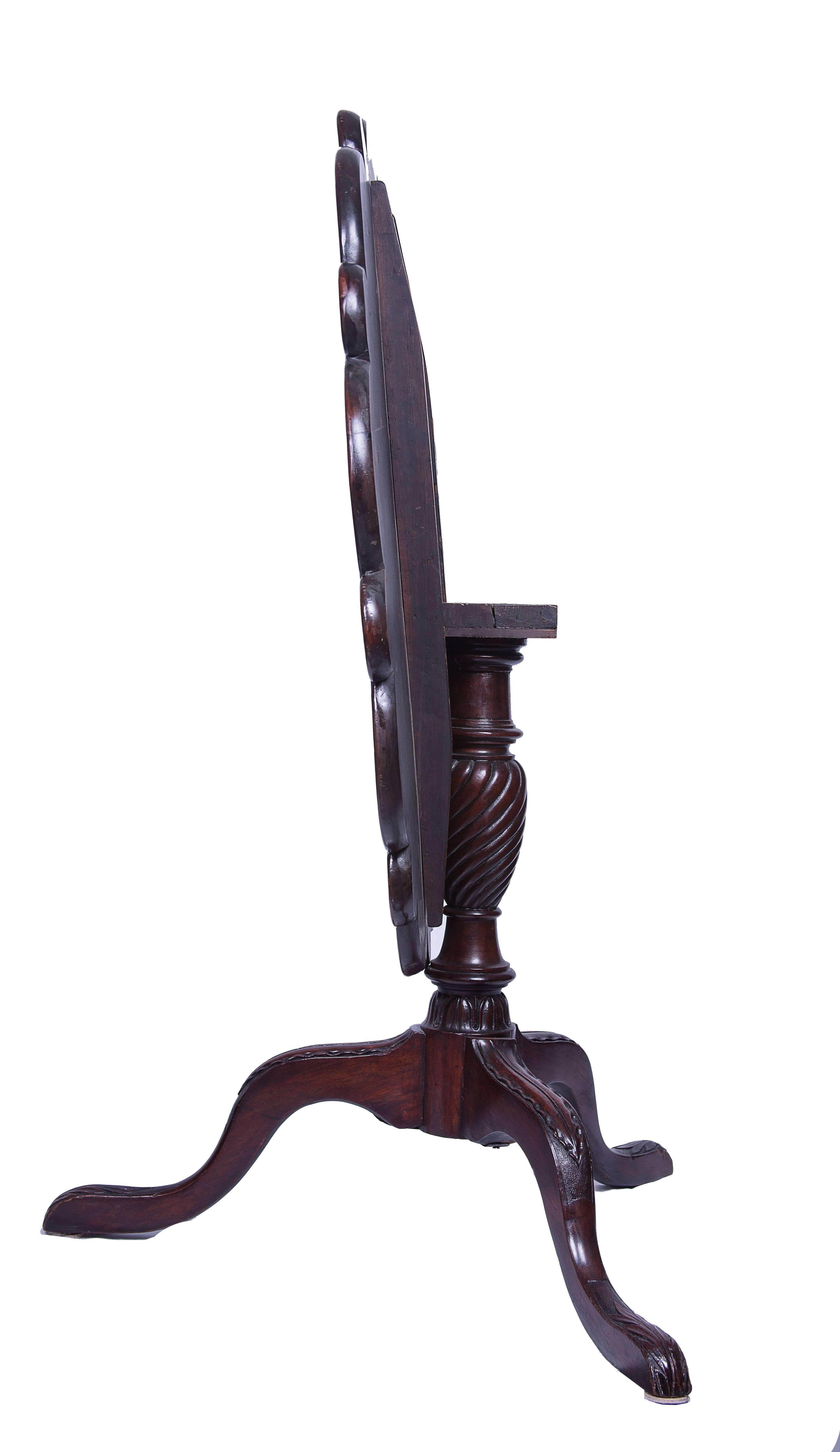 English Georgian mahogany tilt-top supper or tea table. Carved top designed for place settings or serving plates over turned support ending on a tripod base with pad feet.