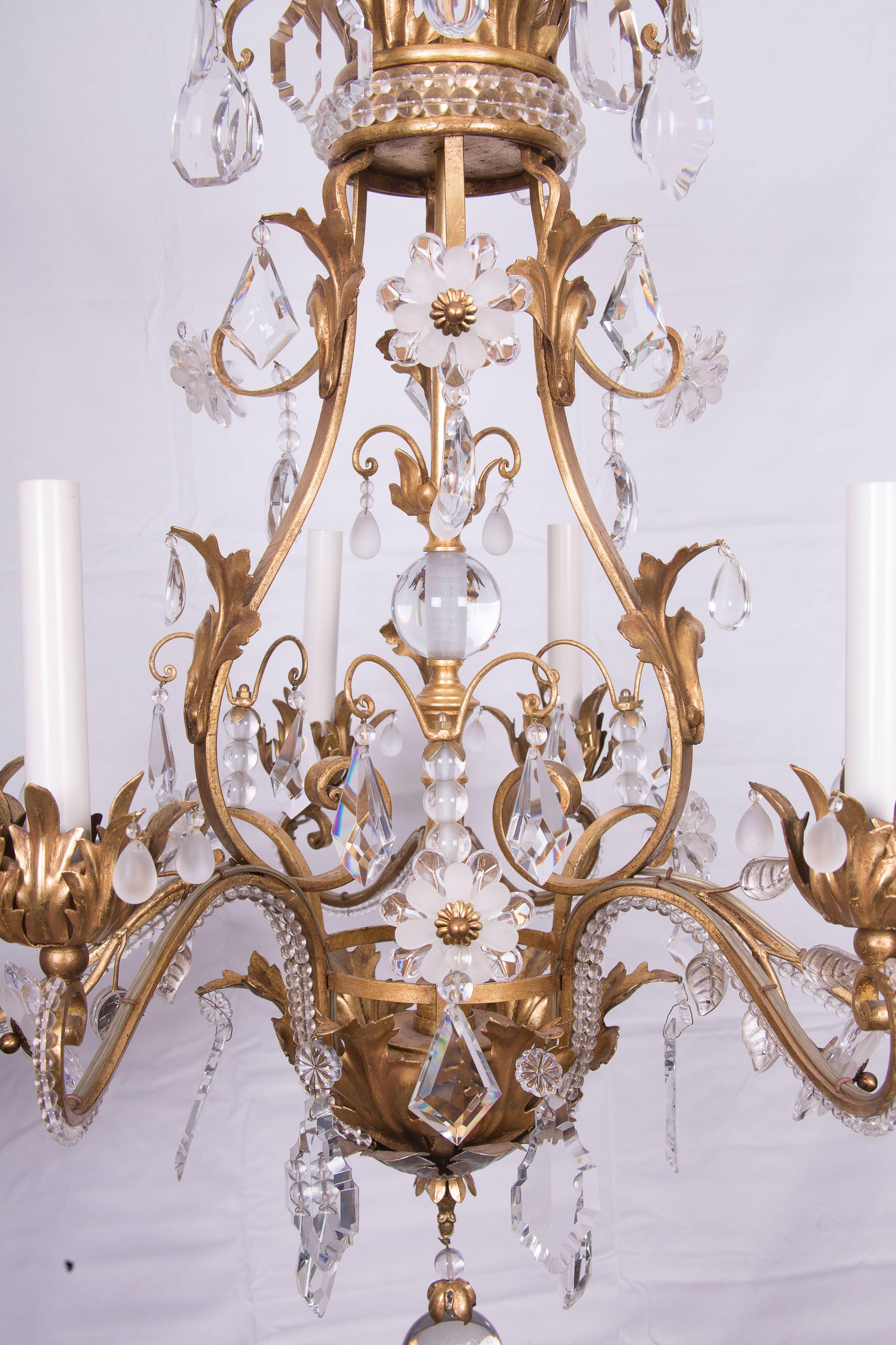 Superb Baguès crystal and gilded six-light chandelier. Decorated with crystal beads and flowers formed with faceted clear and frosted crystal. Gilt metal frame decorated with crystal beads.