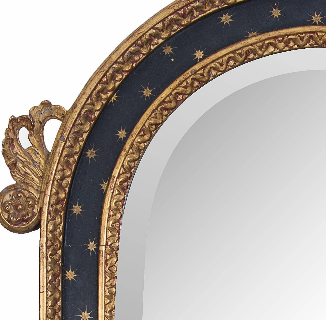 An Italian hand-carved ebonized and giltwood wall mirror. Pleasing combination of gold and ebonized decoration.