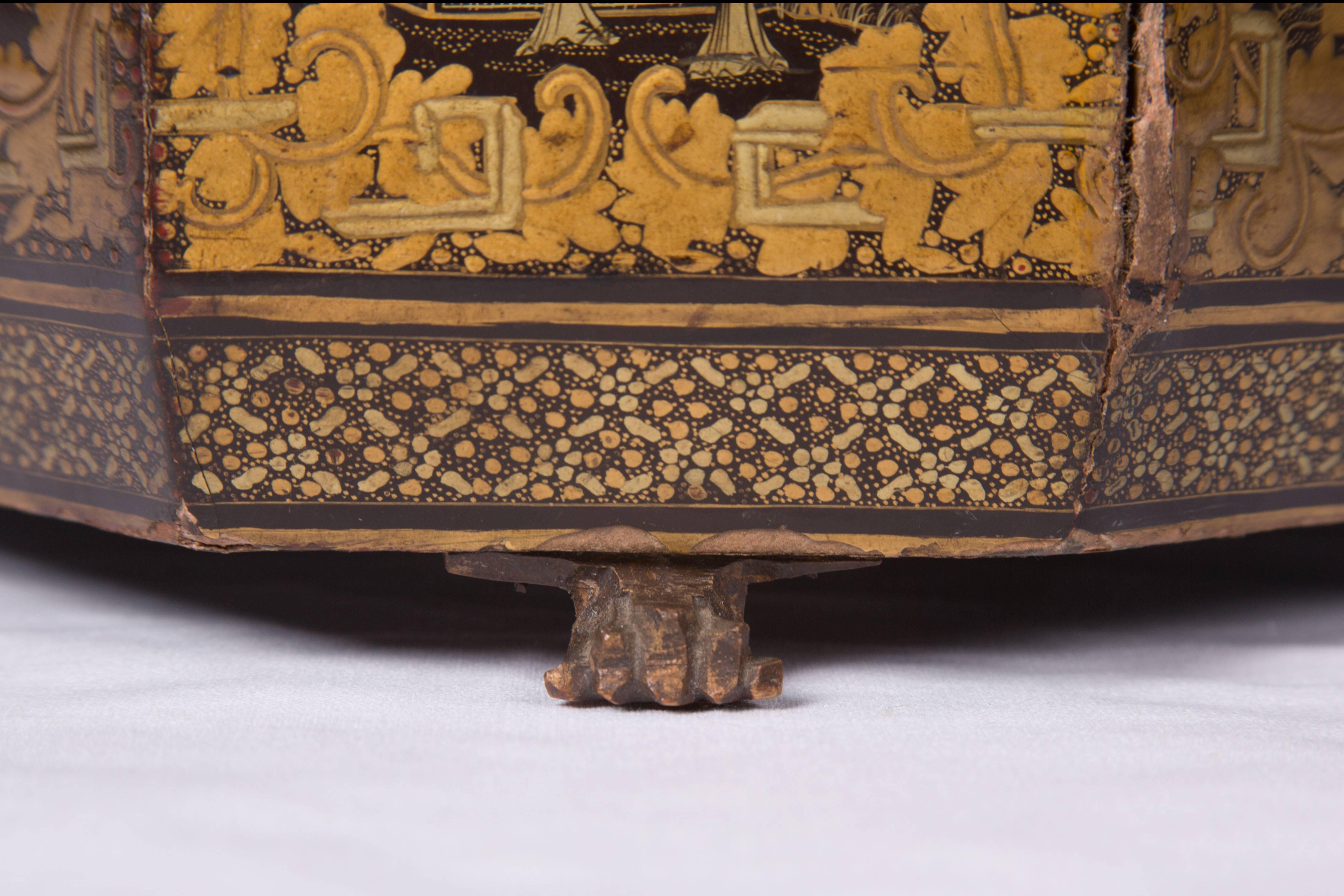 Pictured is an elegant Chinese black lacquered box decorated with finely detailed gilt chinoiserie scenes framed by floral borders. The box is raised on paw feet, late 19th century.