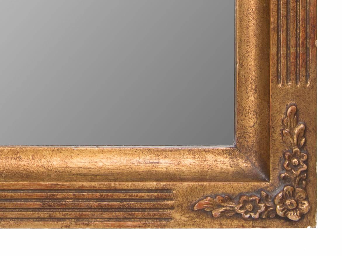 This is an Italian giltwood mirror with architectural fluted frame having gently rounded corners at the top, all surrounding glass plate, late 20th century.