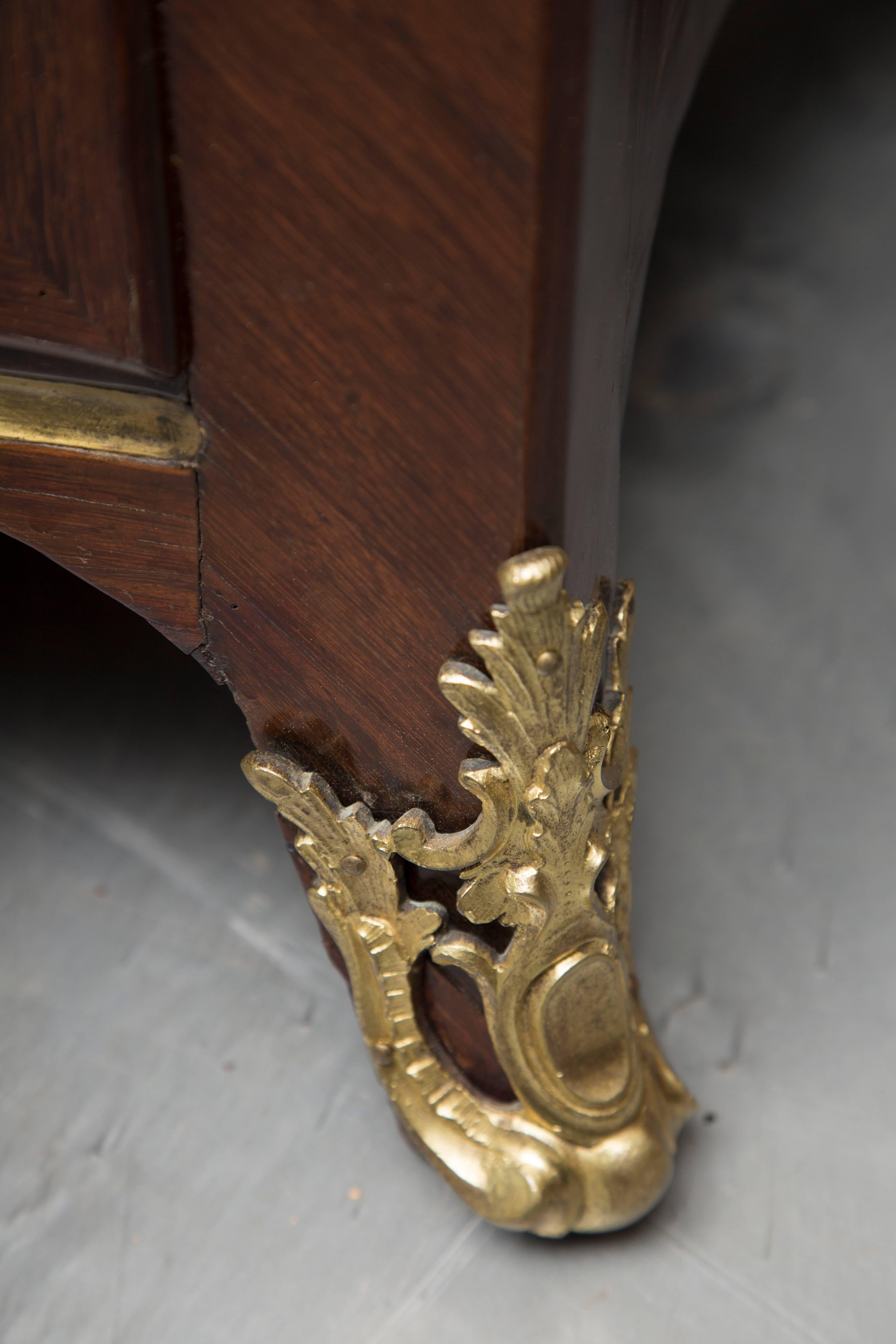 This is an elegant French Louis XV kingwood commode, stamped Saunier (both front corners), with a double serpentine top with ogee edge over conforming case containing three long drawers over a shaped frieze raised on splay feet. The entire case