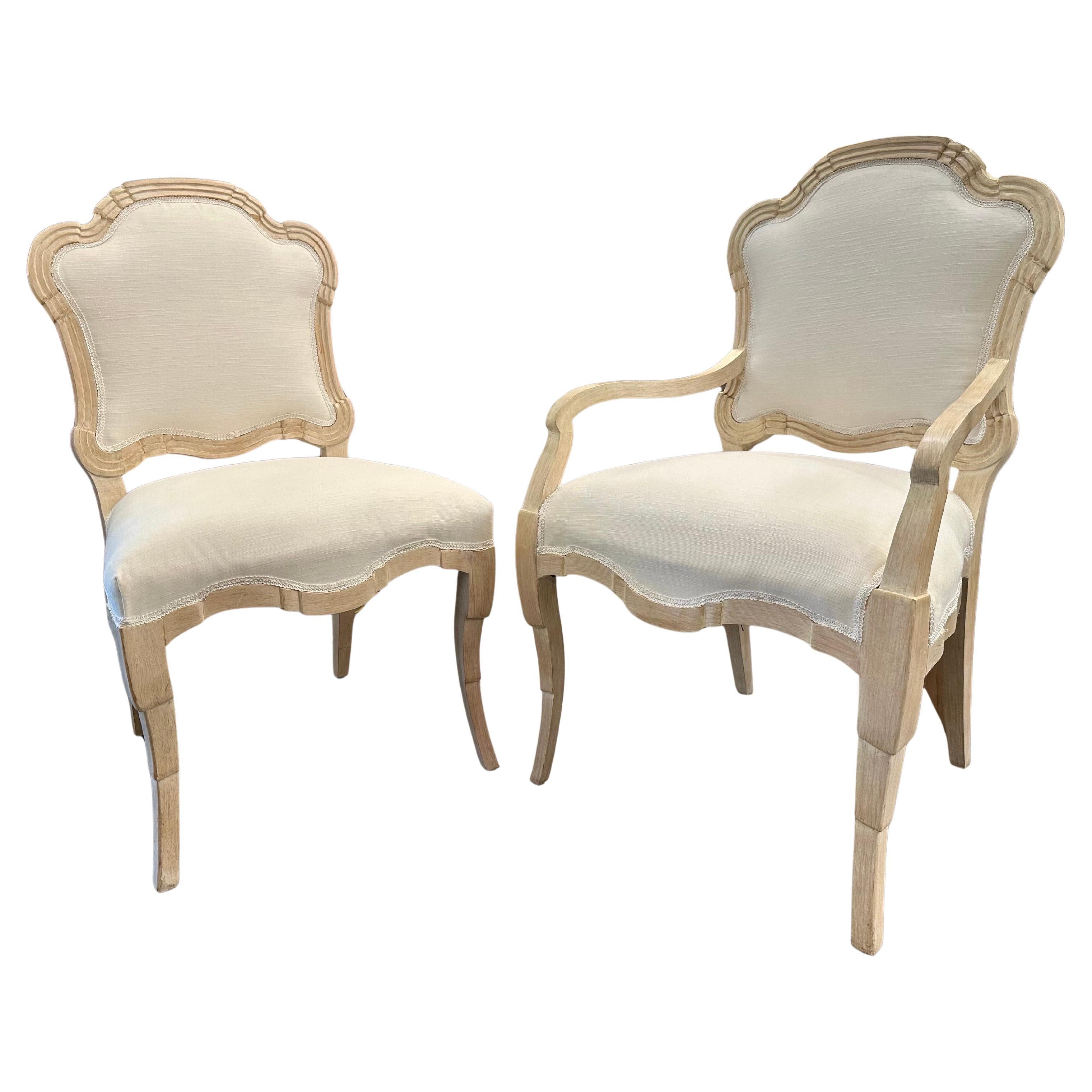 Es handelt sich um einen Satz von sechs stark stilisierten, cremefarbenen Esszimmerstühlen im Louis-XVI-Stil, bestehend aus zwei Sesseln und vier Beistellstühlen, frisch gepolstert mit einem eleganten weißen Stoff, 20. Jahrhundert.