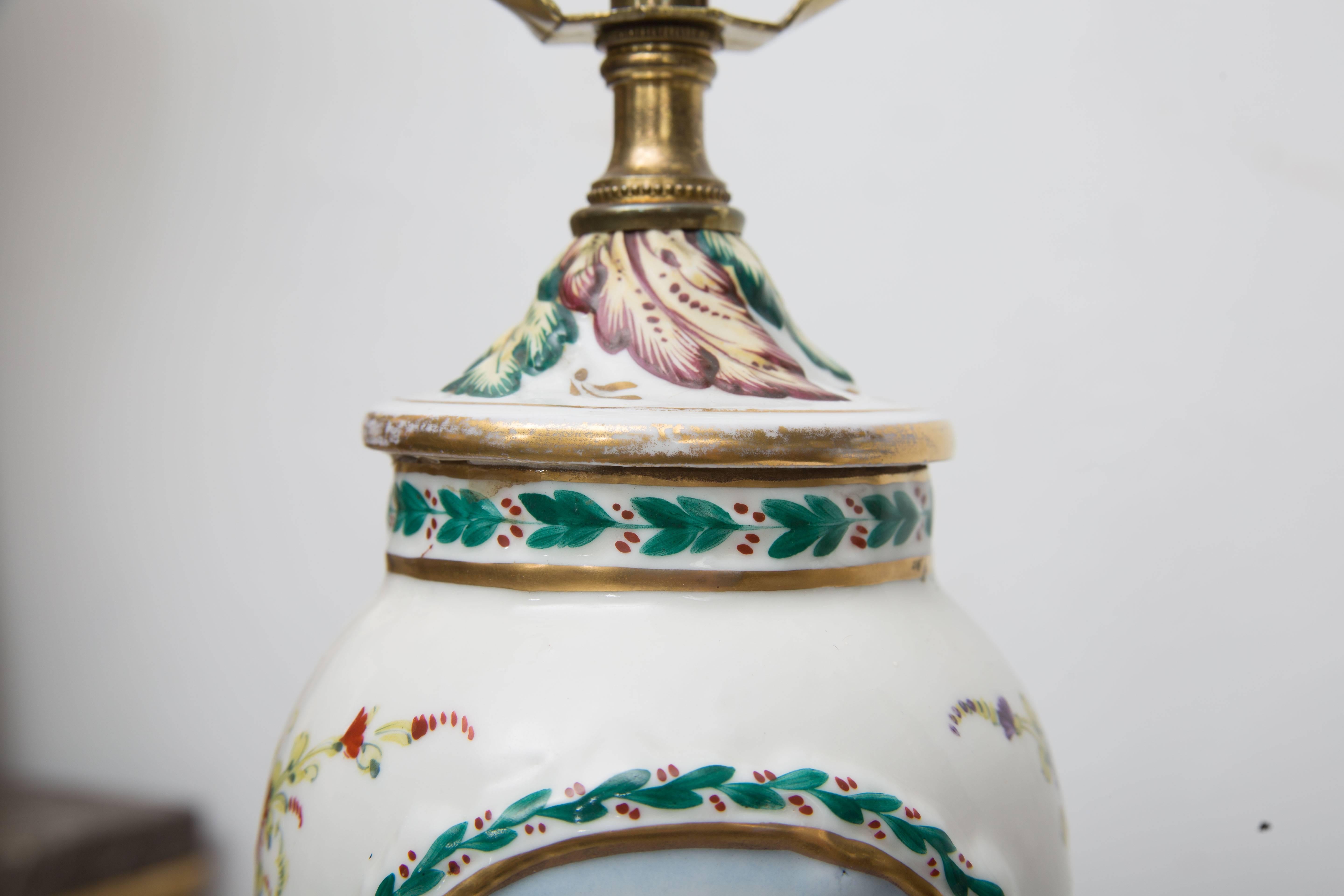 This delightful pair of porcelain Capodimonte vases have been converted to table lamps. The vases have a raised pattern and are hand-painted and mounted on a two-tier gold leaf plinth, circa 1900.