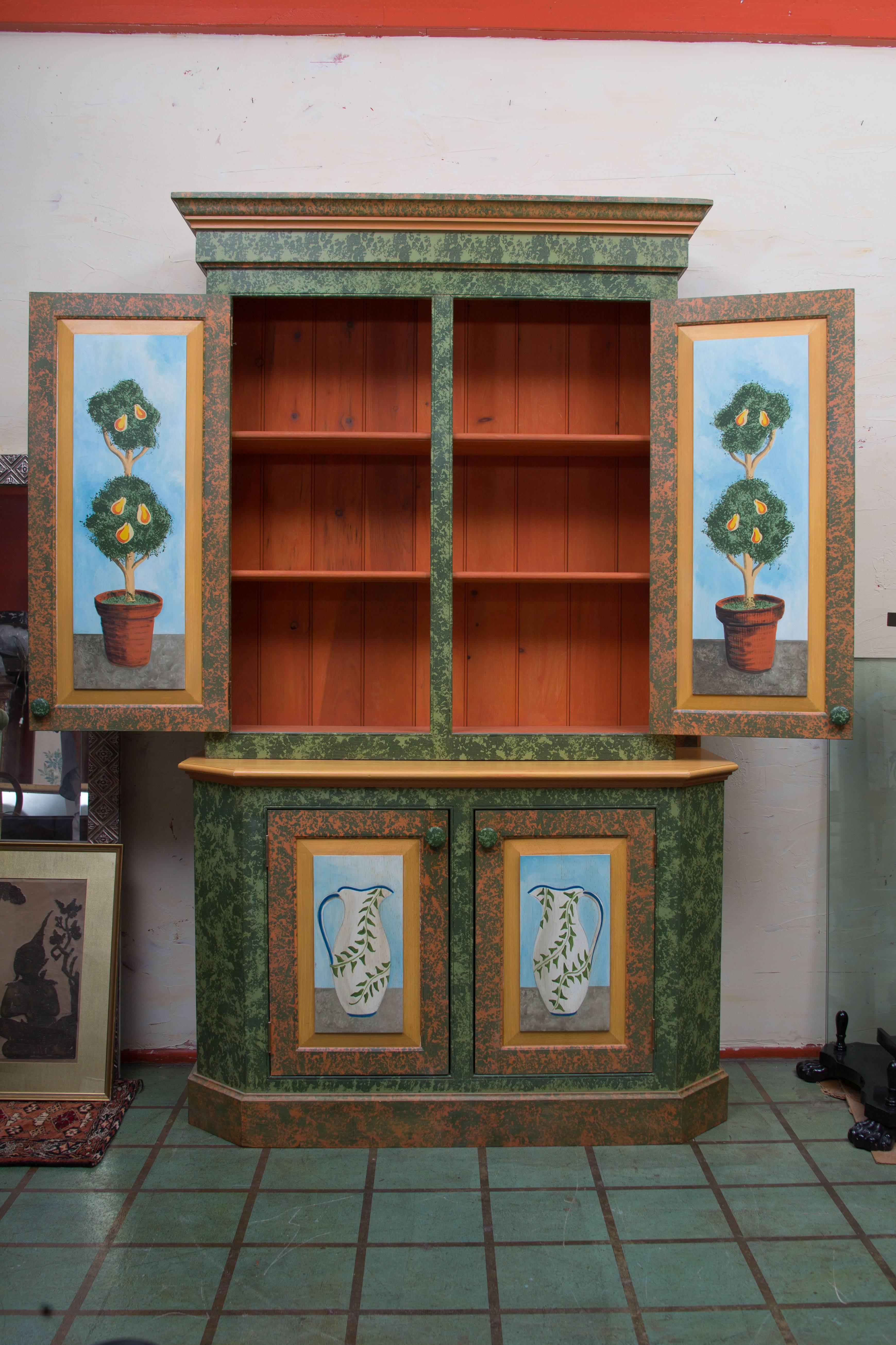 This hand-painted cabinet 'pops' with color and will make any room come alive. The top cabinet doors are painted with fruited topiaries in terra cotta pots in a natural setting. They open to a painted interior with shelving. The bottom section doors