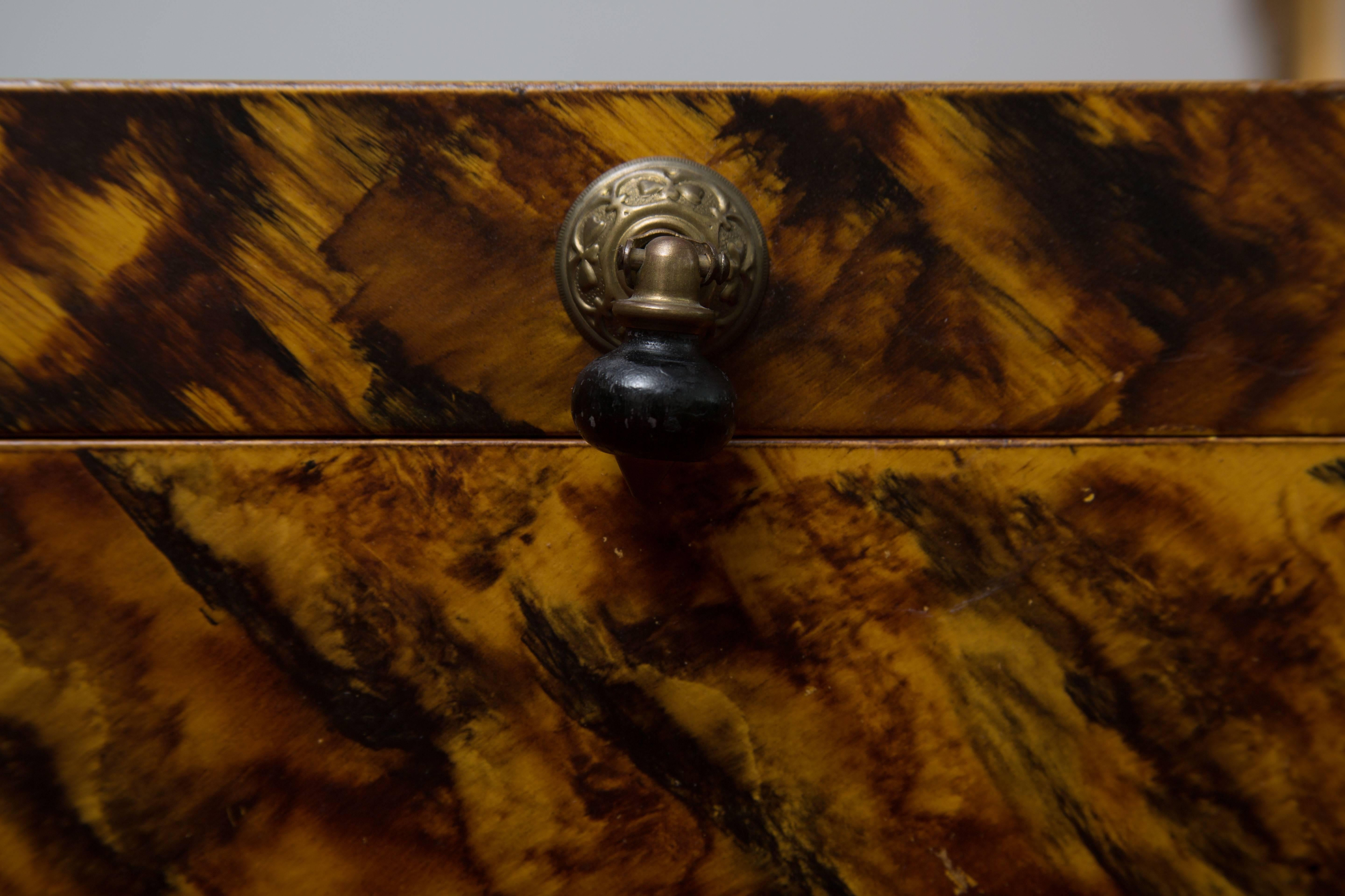 This handsome lidded box has been painted with a faux tortoise finish with a Victorian drop pull, 20th century.