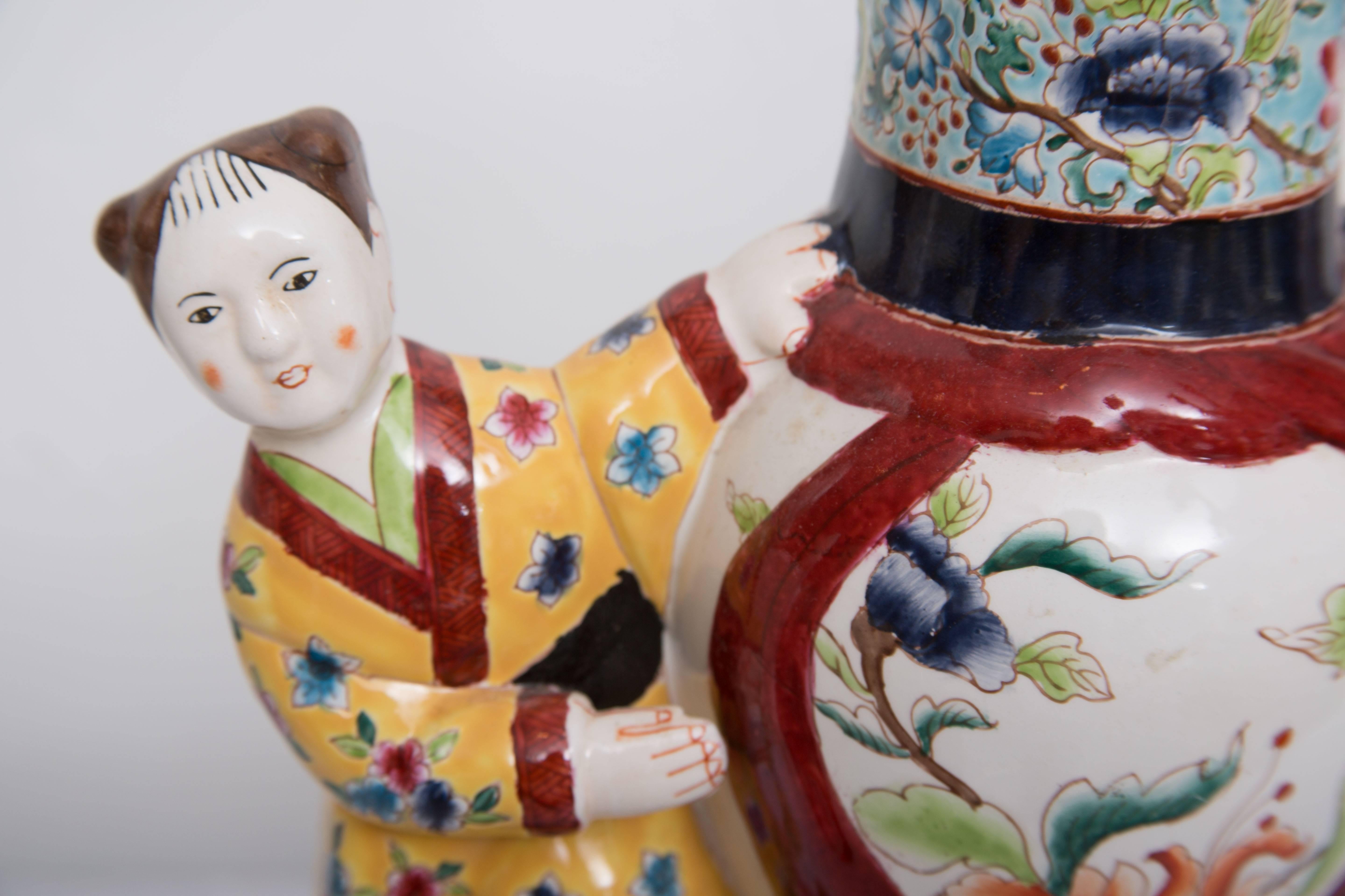 Colorful Mid-Century Asian figure dressed in Classic costumes flank a Chinese palace vase in a whimsical pose. These fun and fanciful Mid-Century figurine has been mounted and electrified as high style table lamps, circa mid-20th century.
Only one