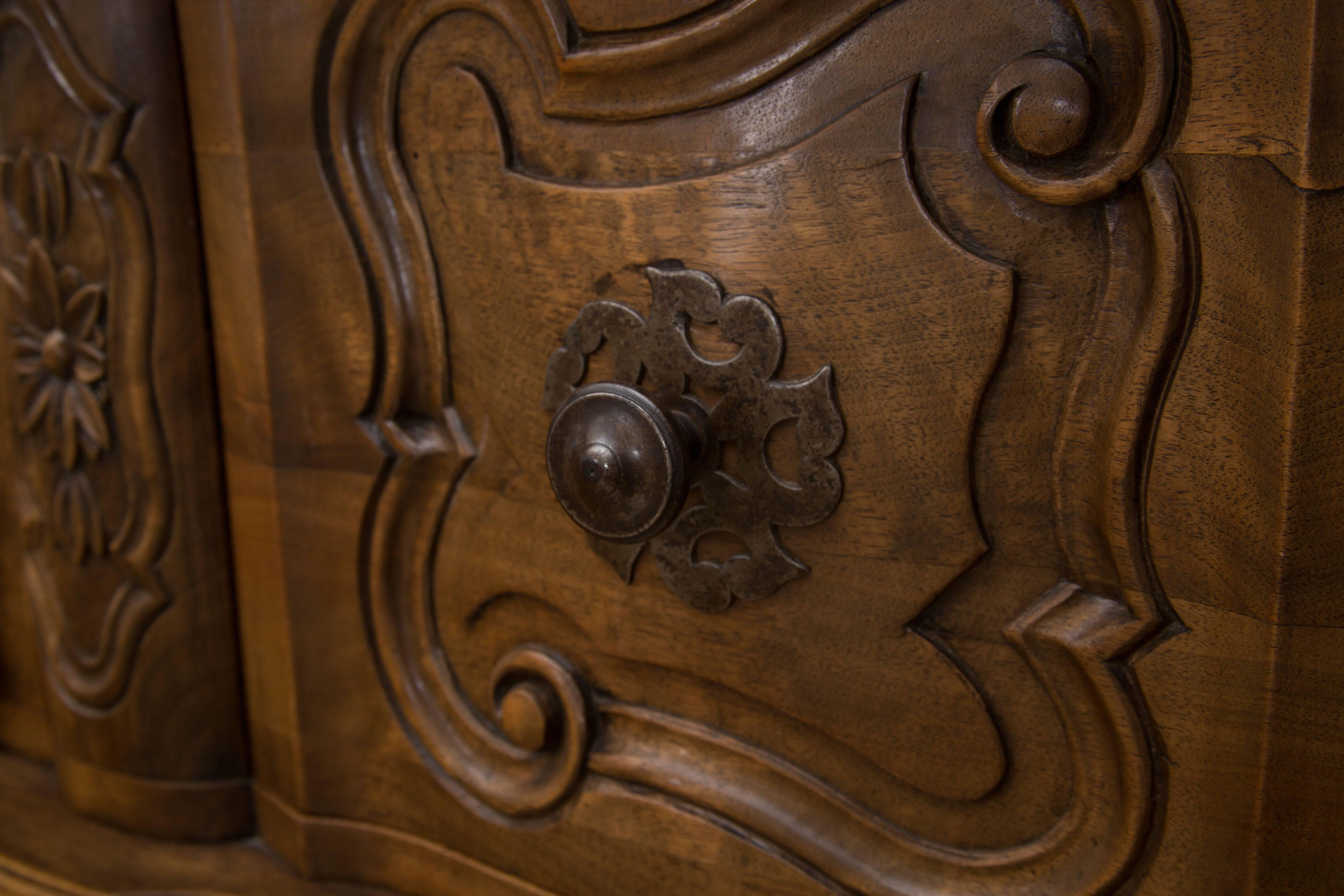 Dieses schöne, auf der Bank gefertigte, kunstvoll geschnitzte Buffet aus französischem Nussbaum im Stil Ludwigs XV. hat die Besonderheit, dass es auf der Oberseite eine Superstruktur mit drei Schranktüren hat, die auf einem Buffet mit einer