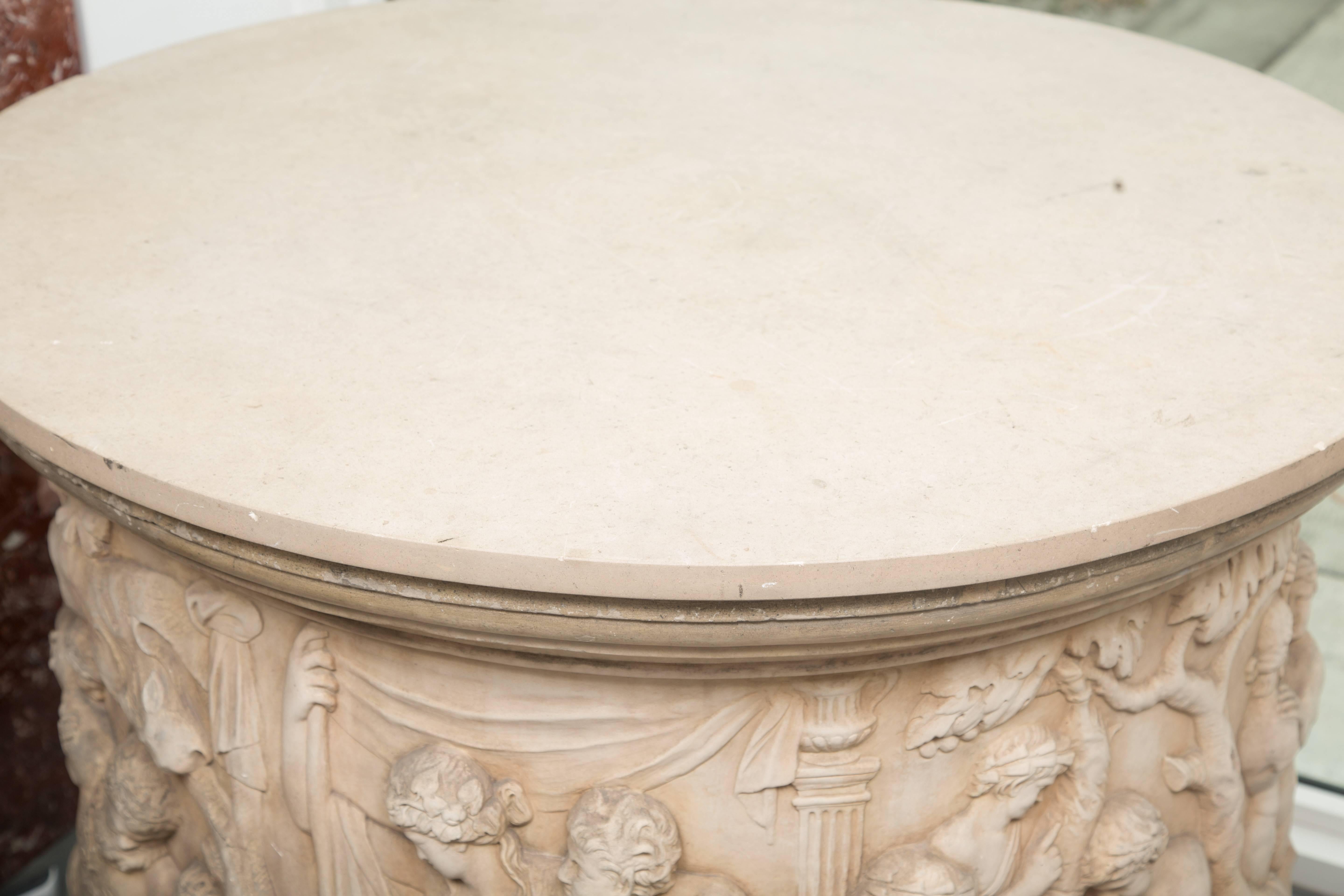 This impressive circular fountain has been assembled as a center table with later lime stone top. The item depicts classic figures in naturalistic vignettes representing various lifestyles. 20th century.