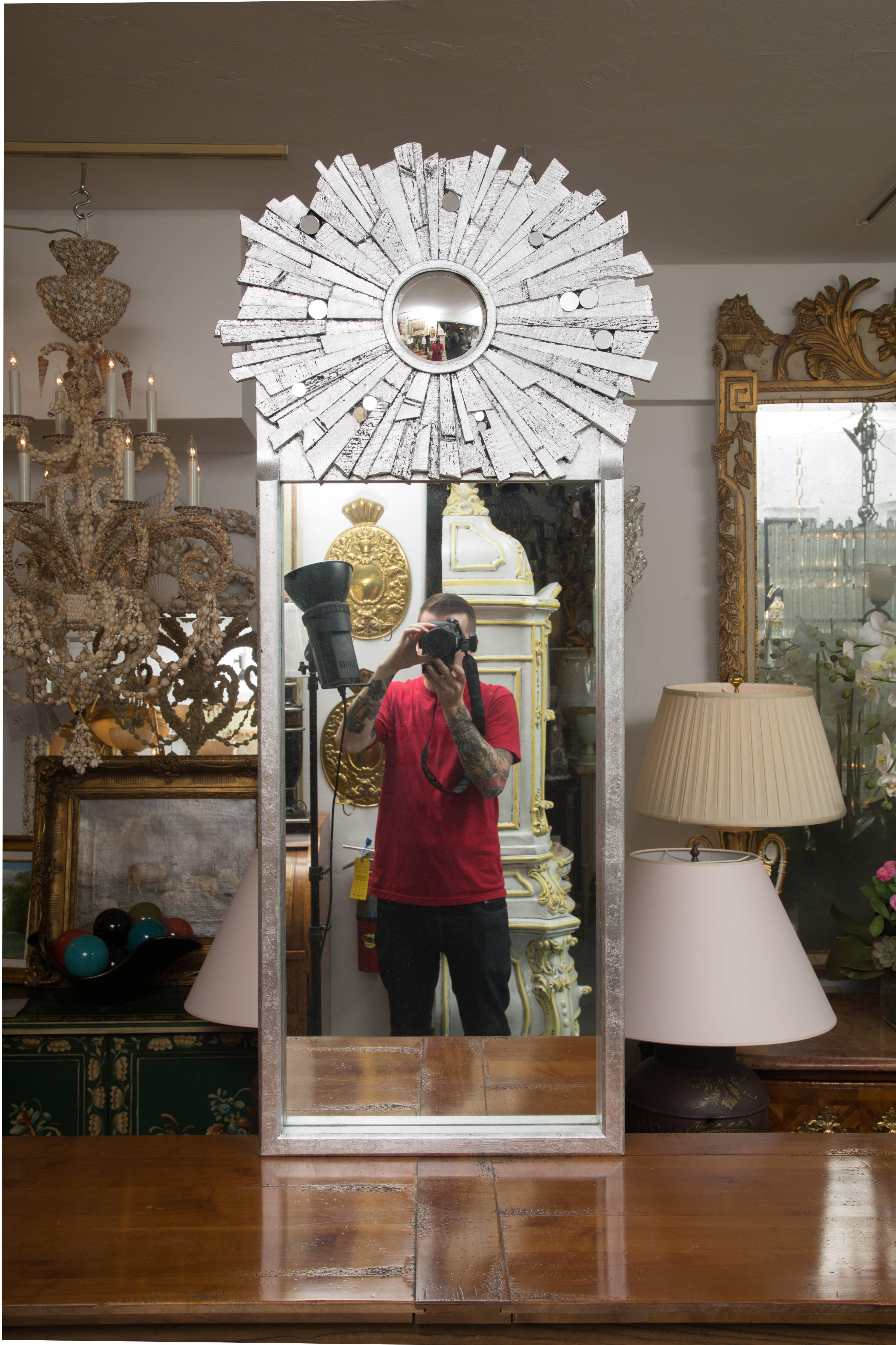 These unique silver-painted contemporary mirrors have a sunburst top section with rough hewn spokes radiating from a central convex mirror over a rectangular mirrored bottom section. Considered 