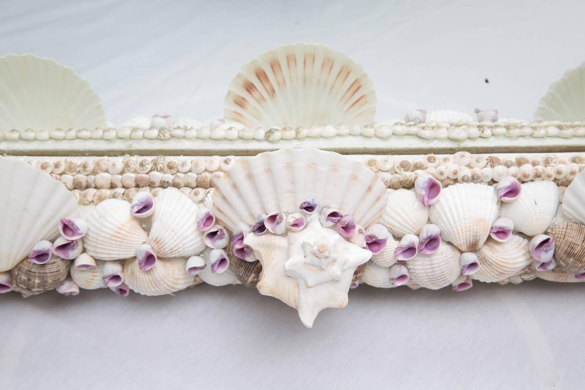 This domed mirror is a beautiful rendition of shell art creating a mirror plate framed by a combination of shells of various types and shapes, 21st century.
