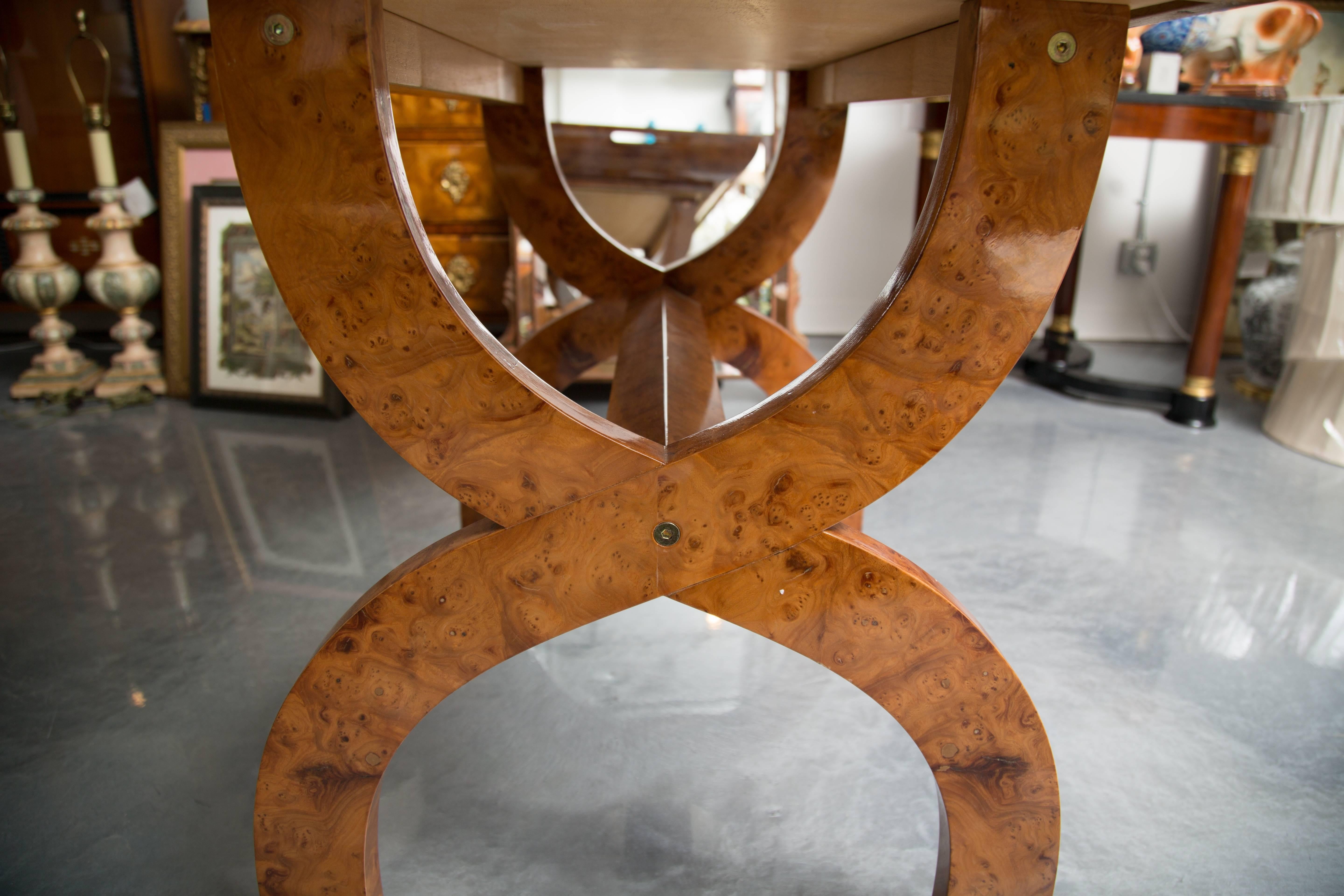 This is an elegant and unique amboyna wood tray within a deep recessed frame containing openings at the ends, enabling the large tray to be lifted off the base. The tray is stabilized by a pair of curved X-shaped supports joined by a round