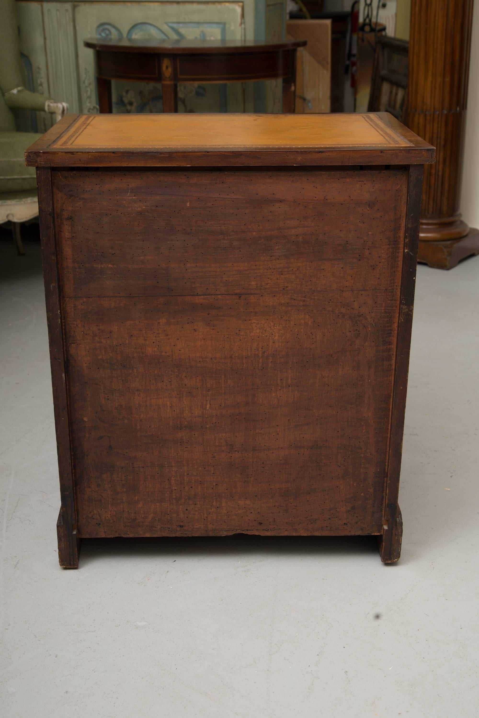 This is an unusual English Regency mahogany knee hole desk, the top with leather inset, above a frieze drawer flanked by a pair of pilasters with brass capitals and collars, situated on a plinth base, circa 1840.