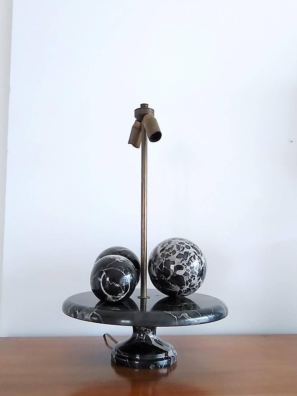 Unusual table lamp with three black Carrara marble balls laid on a similar marble 