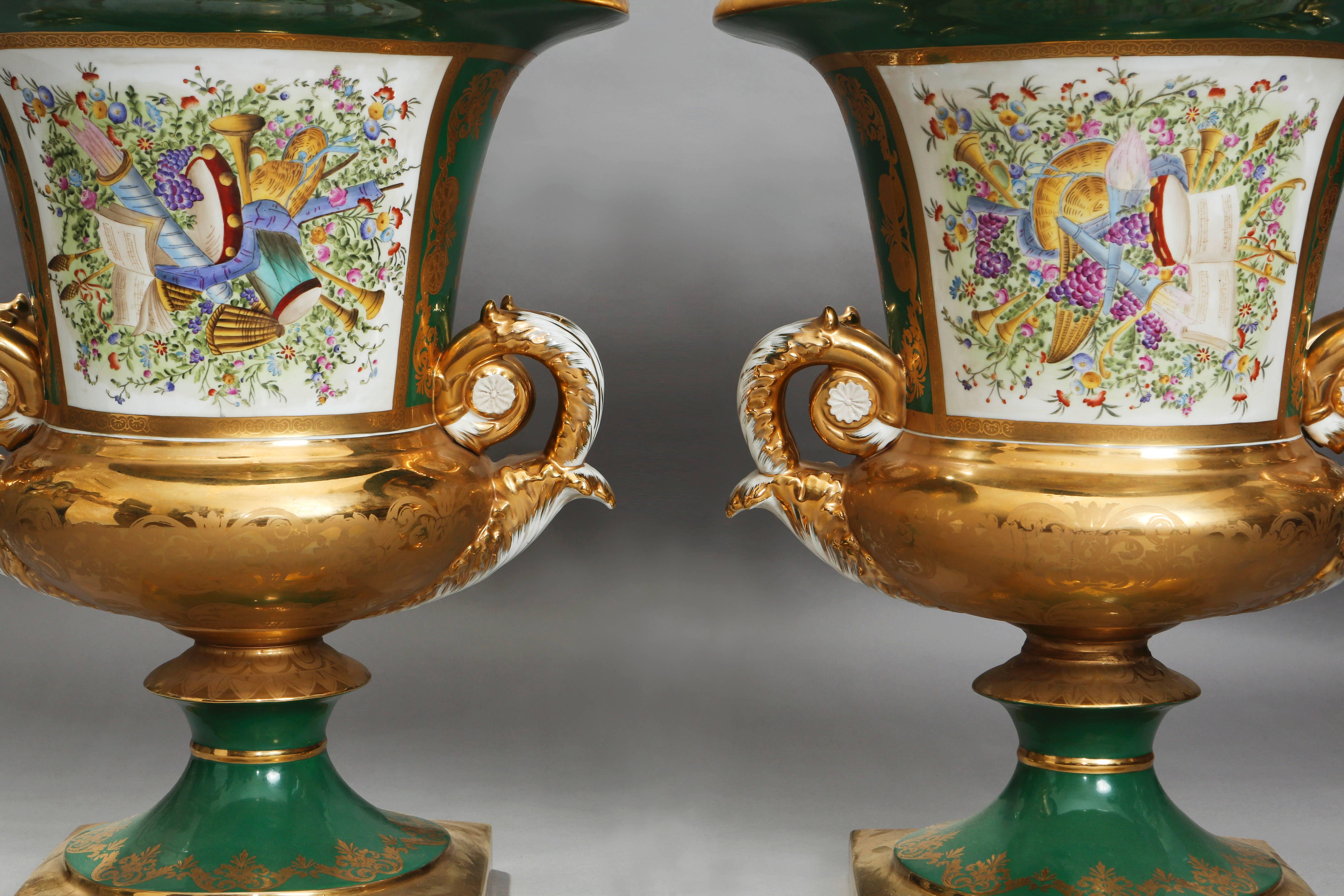 A pair of large 19th century Russian gardner porcelain campana urns. The urns are molded with a square plinth-like base. Each feature green backgrounds with heavy decorative gold gilding, that has patterns of its own within it created through the