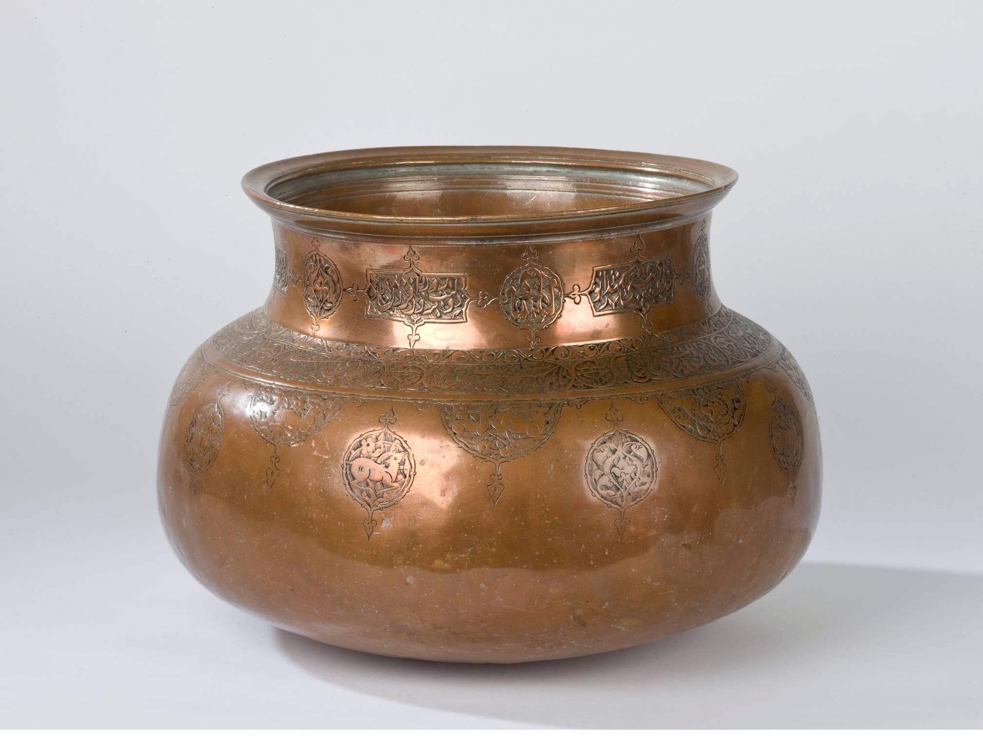 A 17th century Safavid copper basin decorated with calligraphic motifs and cartouches of prancing fauna.