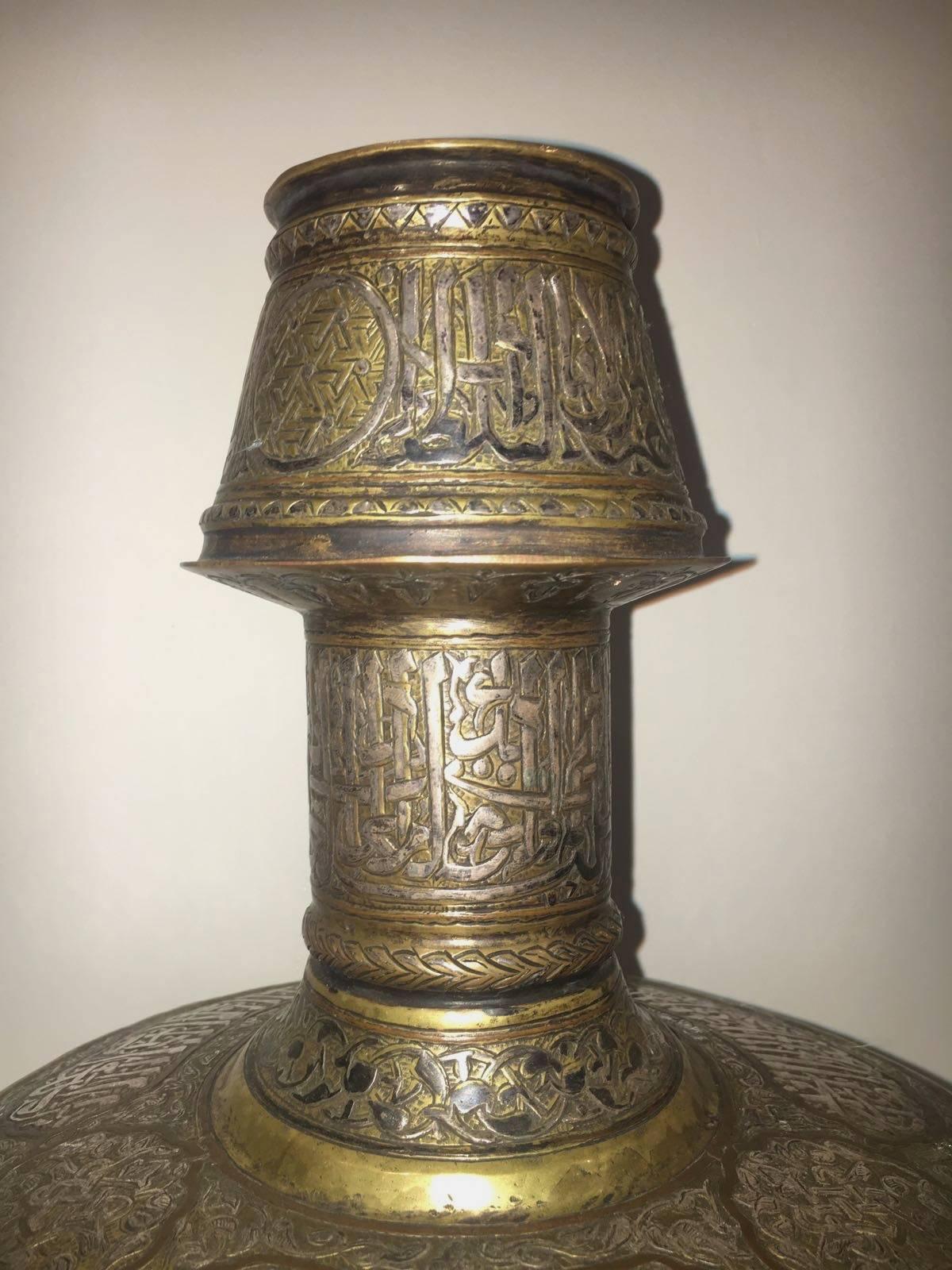 A 20th century Mamluk Revival candlestick made of copper with silver inlay featuring various Arabic inscriptions. In an excellent condition.
