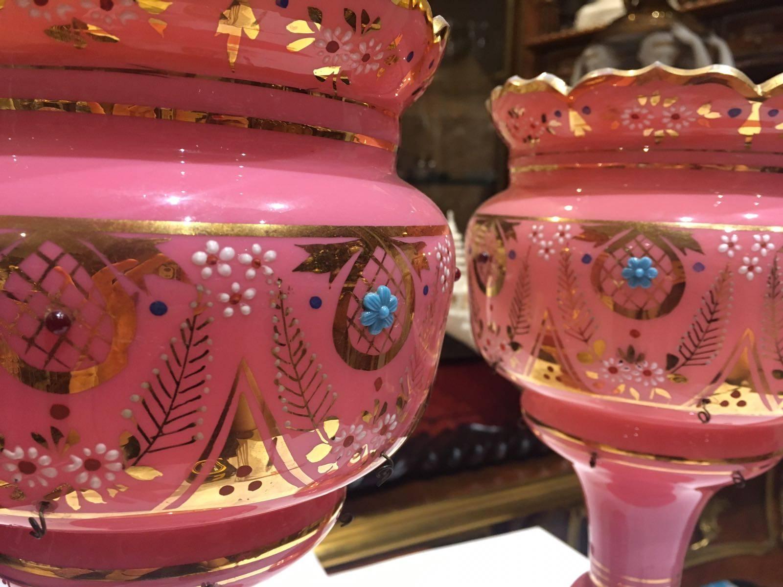 Pair of bright pink mantle lustres with floral and foliate enamelling

Measures: D 16.5cm, H 31cm.