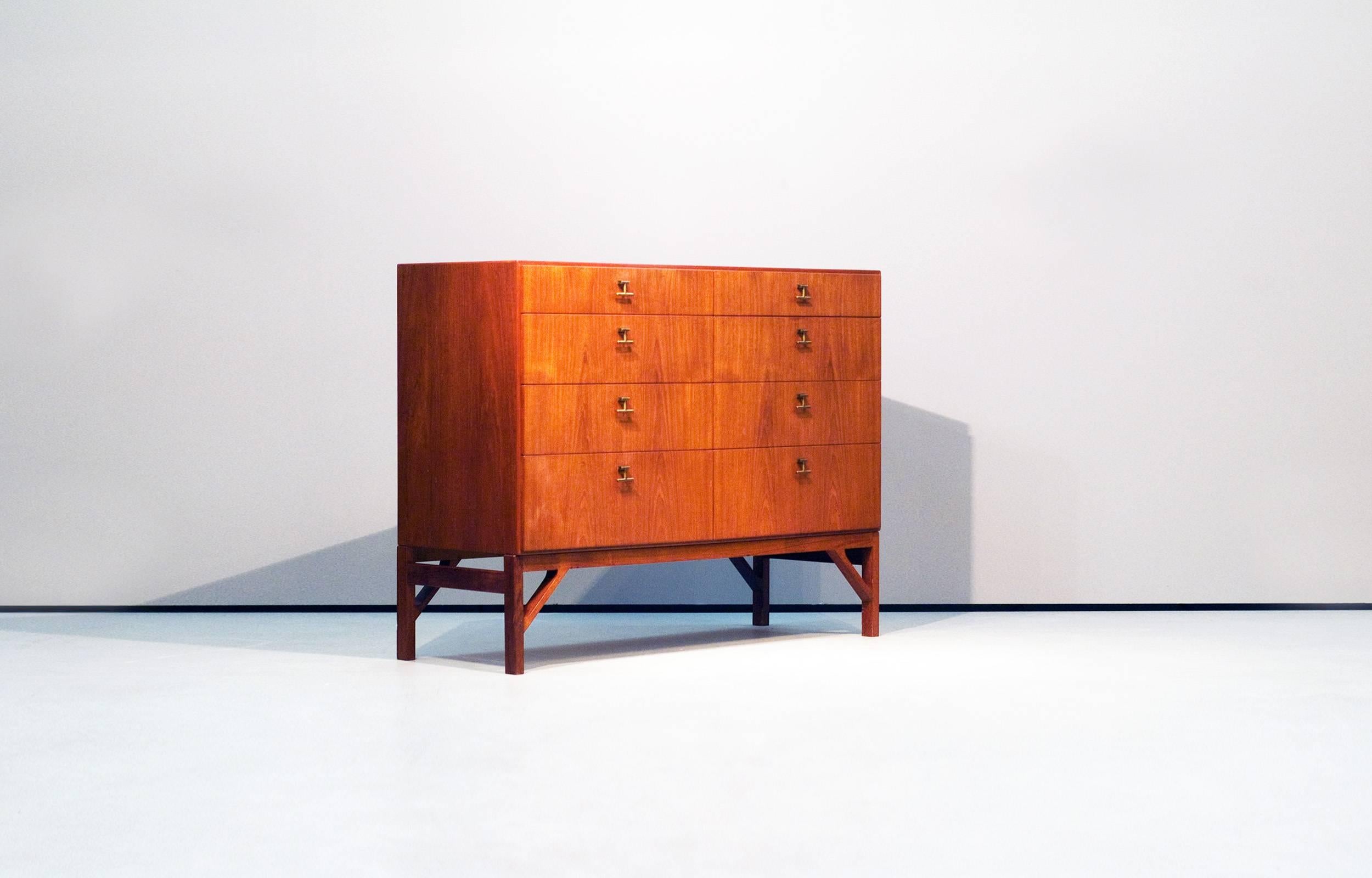 Wonderful teak cabinet with two doors, brass handles and inside drawers. Beautiful details. Rare teak / teak combination. Minimal wear consistent with age and use.