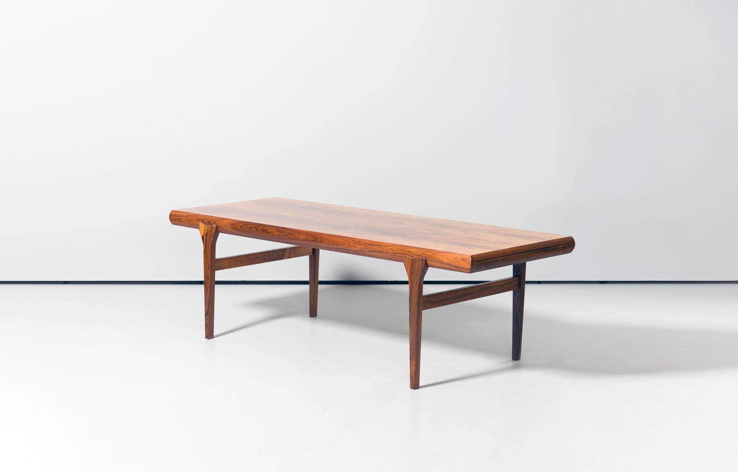 Wonderful coffee table designed by Johannes Andersen and made by Silkeborg. Beautiful grained rosewood veneer seven solid rosewood feet with very nice details.

One extendible drawer (pictured) and one extendible plate.

Perfect restored