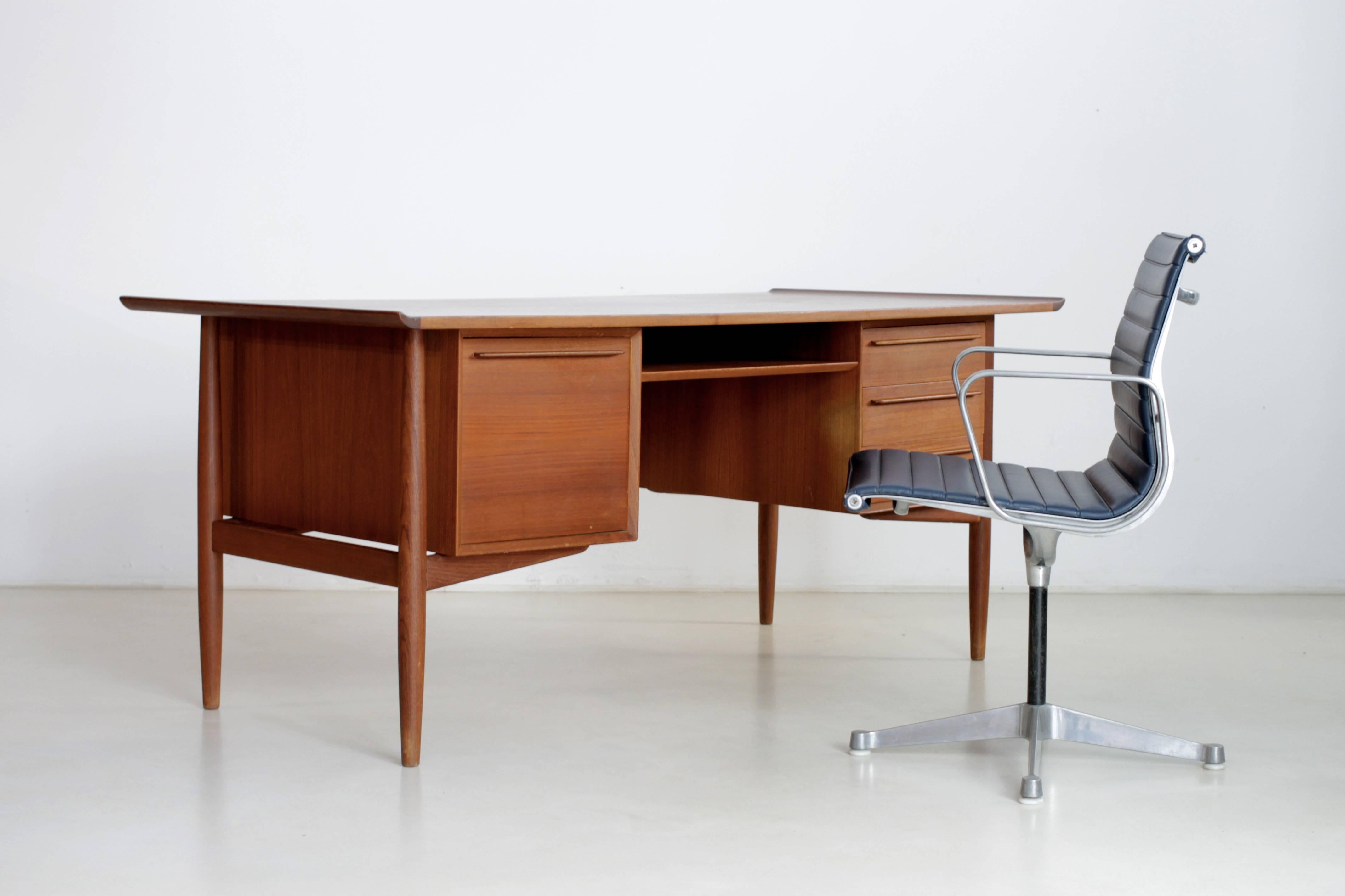 Elegant Danish teak desk designed by Arne Vodder and manufactured by H. P. Hansen in Denmark. Small wear on one of the handles.