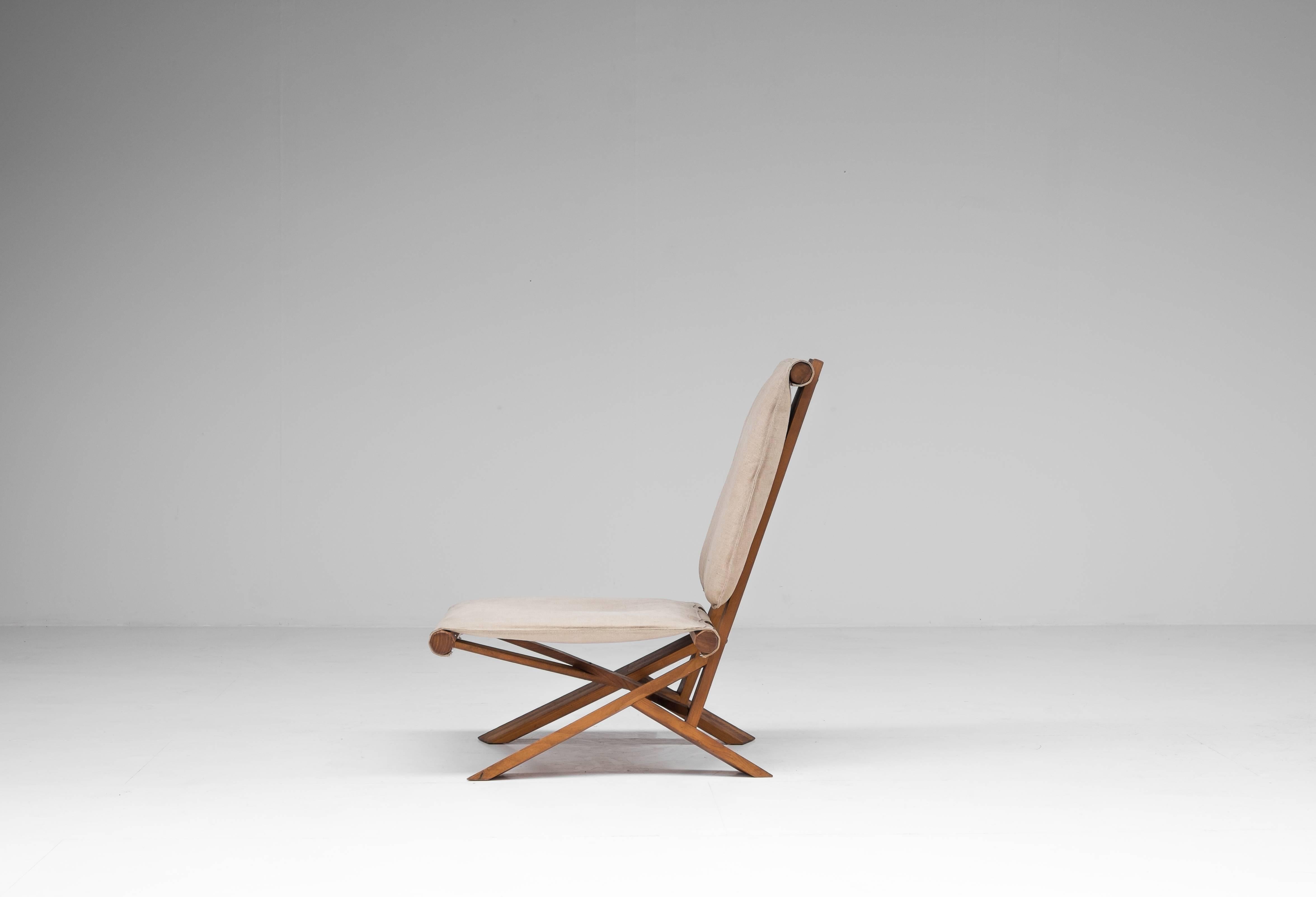 The S46 Dromadaire chair was designed by Pierre Chapo and was produced in France by Ebenisterie Seltz, circa 1980. The frame is made from elm with a canvas upholstery. The weight and shape of the structure of this piece determine its equilibrium and