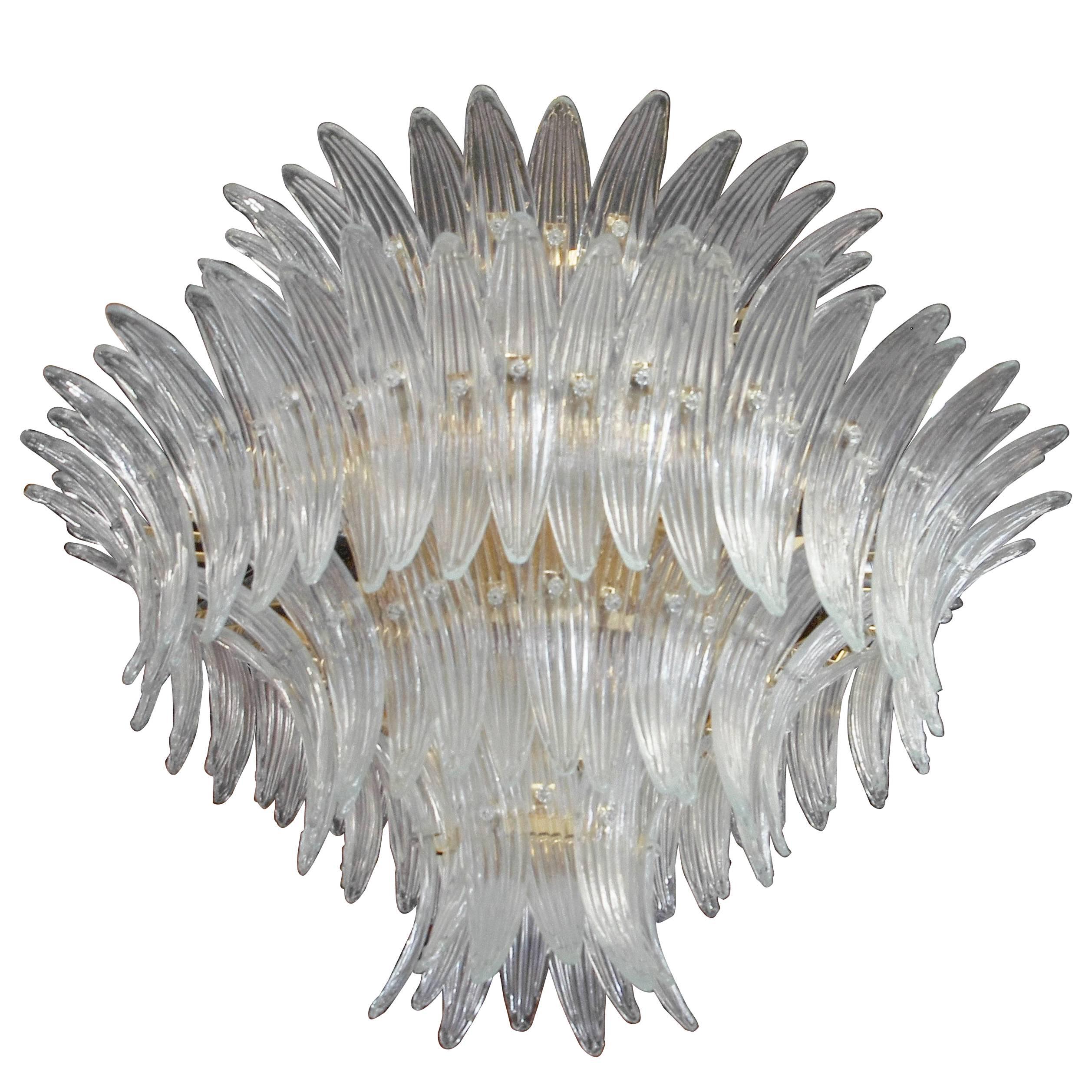 Italian Palmette chandelier with clear Murano glass leaves arranged on four tiers and mounted on gold-plated metal frame by Fabio Ltd / Made in Italy
16 lights / E26 or E27 type / max 60W each
Diameter: 36 inches / Height: 27 inches plus chain and