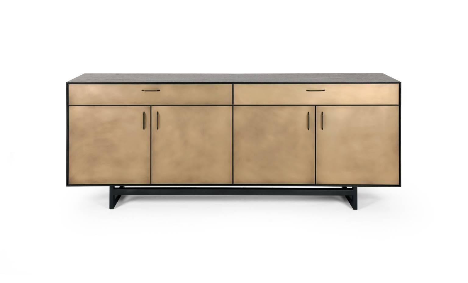 The Gotham credenza features clean lines that blend harmoniously with the beautiful mix of materials. A dark and dramatic oxidized walnut frame sits on a blackened steel base. Custom hand-sculpted blackened bronze pulls compliment the striking