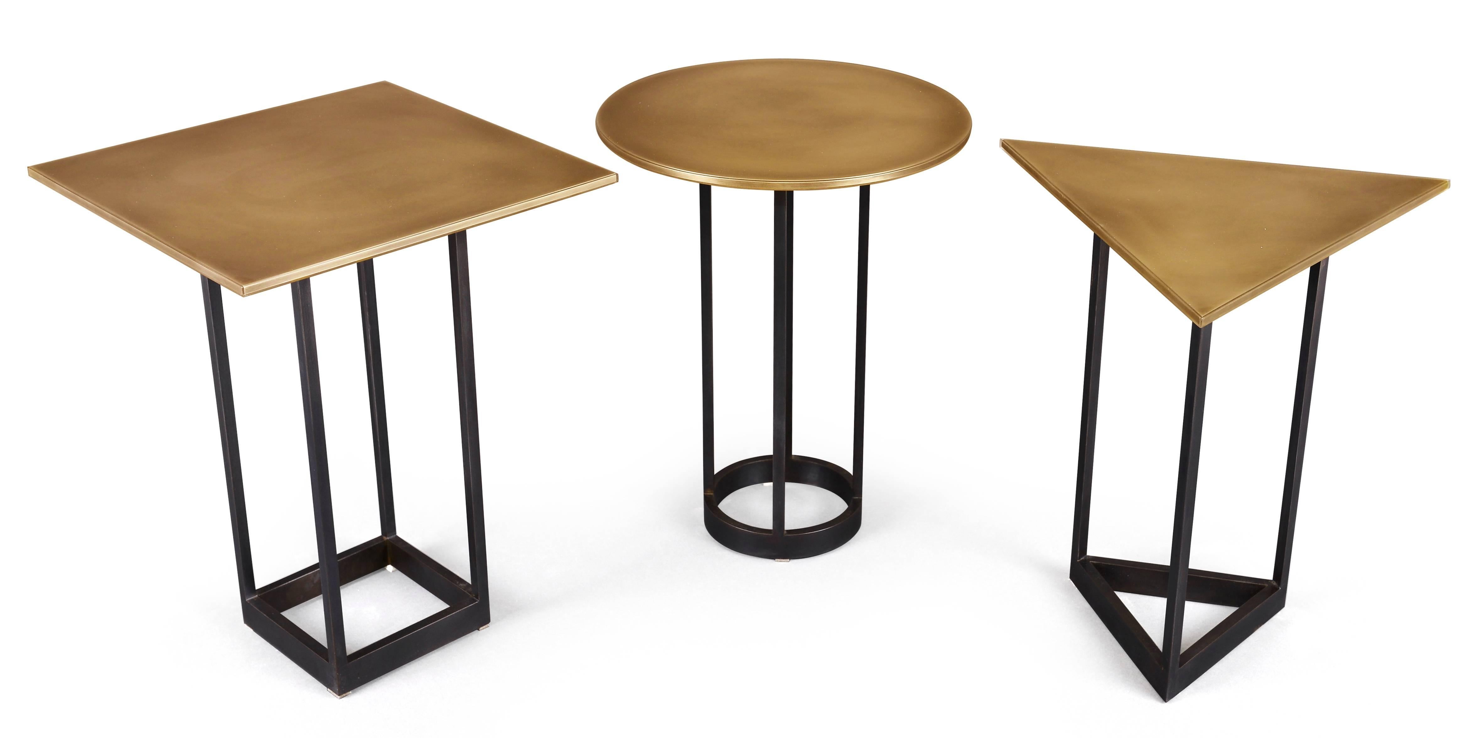 Part of the Gotham collection, these playful and modern geometric shaped end tables can be nested together or separated. Bronze encased in Epoxy Resin tabletops sit atop a blackened steel base. As the resin is non-porous, the table tops are ideal