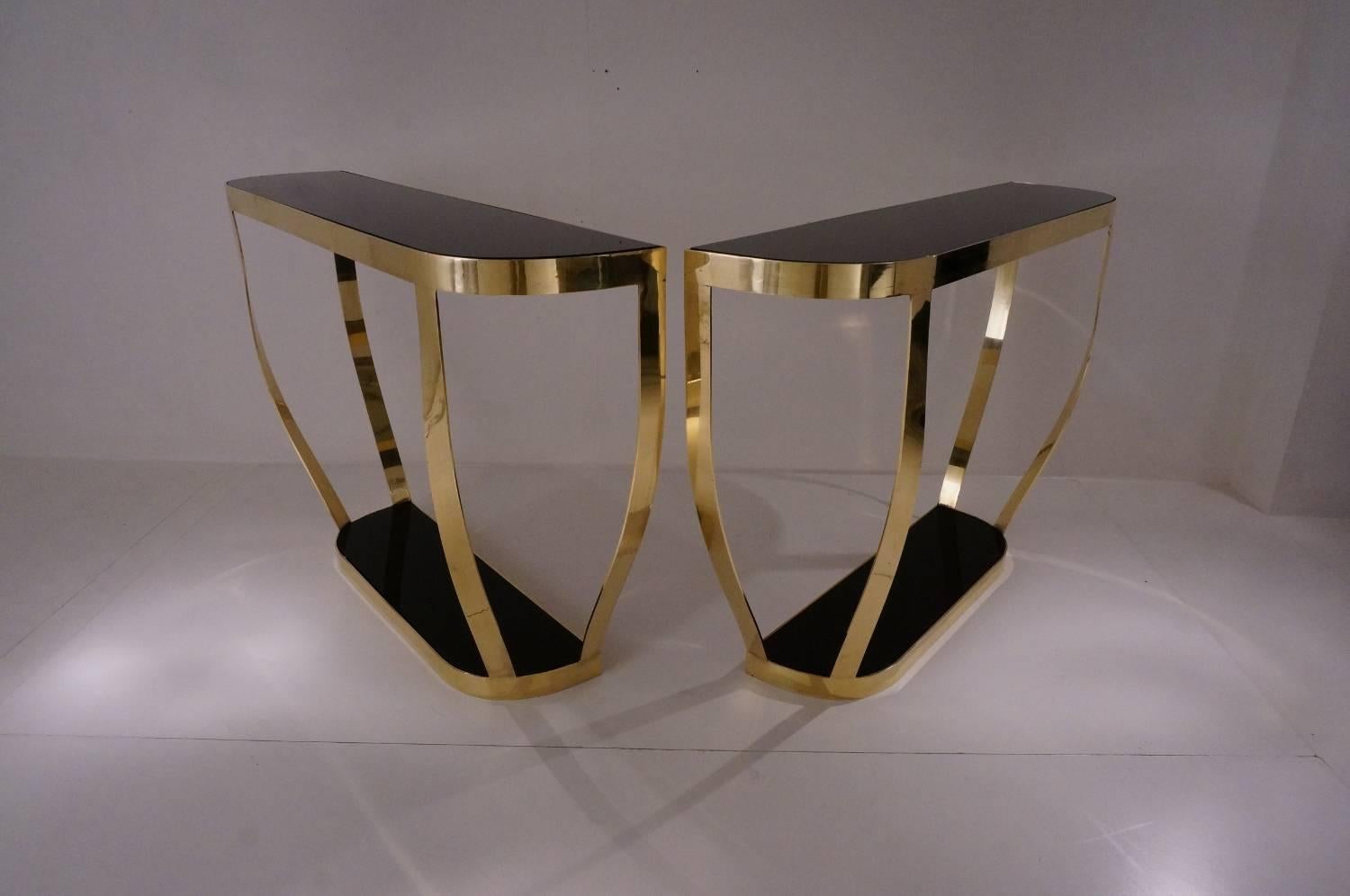 Pair of console tables, solid brass with black glass and shelf, circa 1990s, Italian.

This pair of console tables have been thoroughly cleaned respecting the original patina and are ready to use.

This pair of neoclassical console tables dating